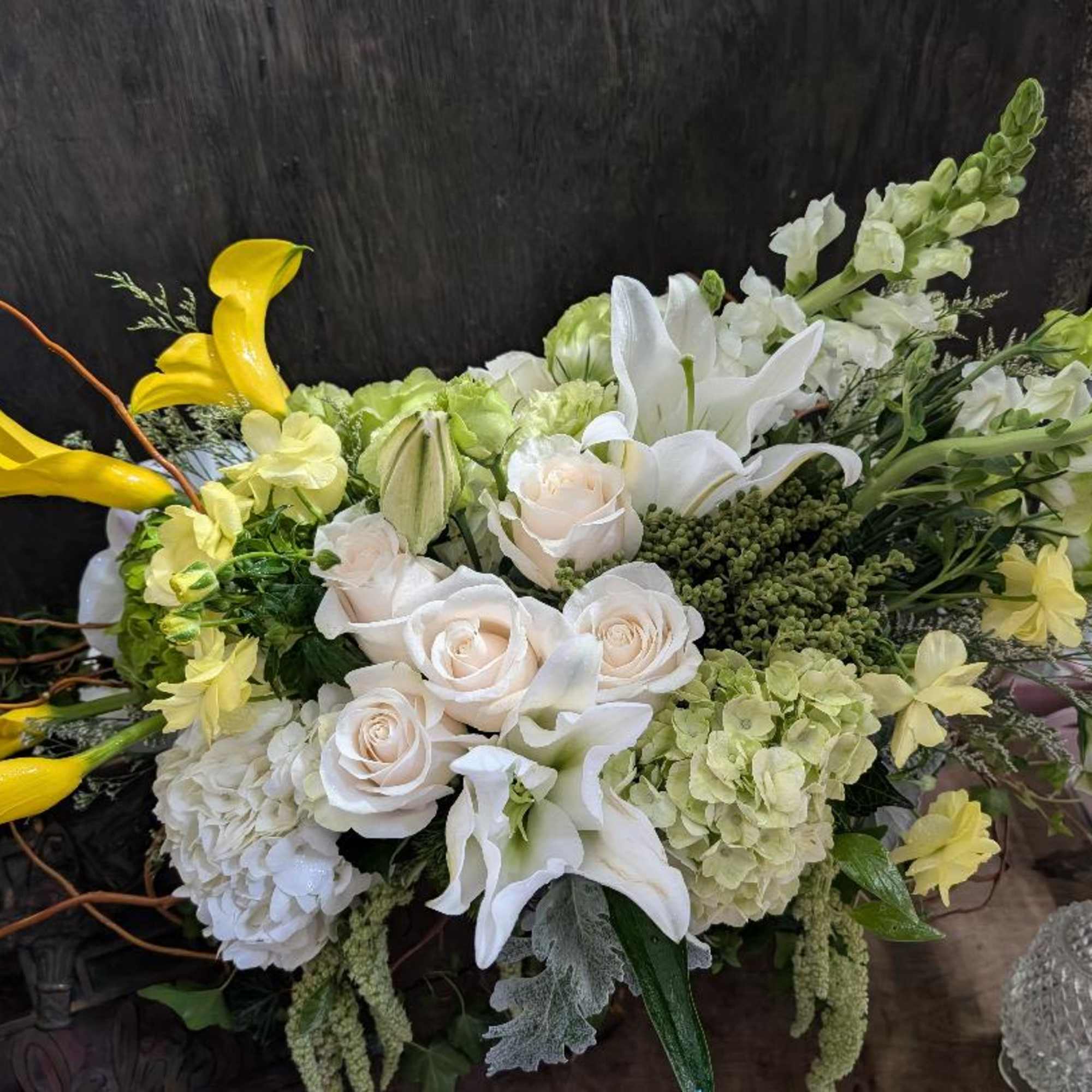 Bouquet of white roses, lilies, and yellow calla lilies