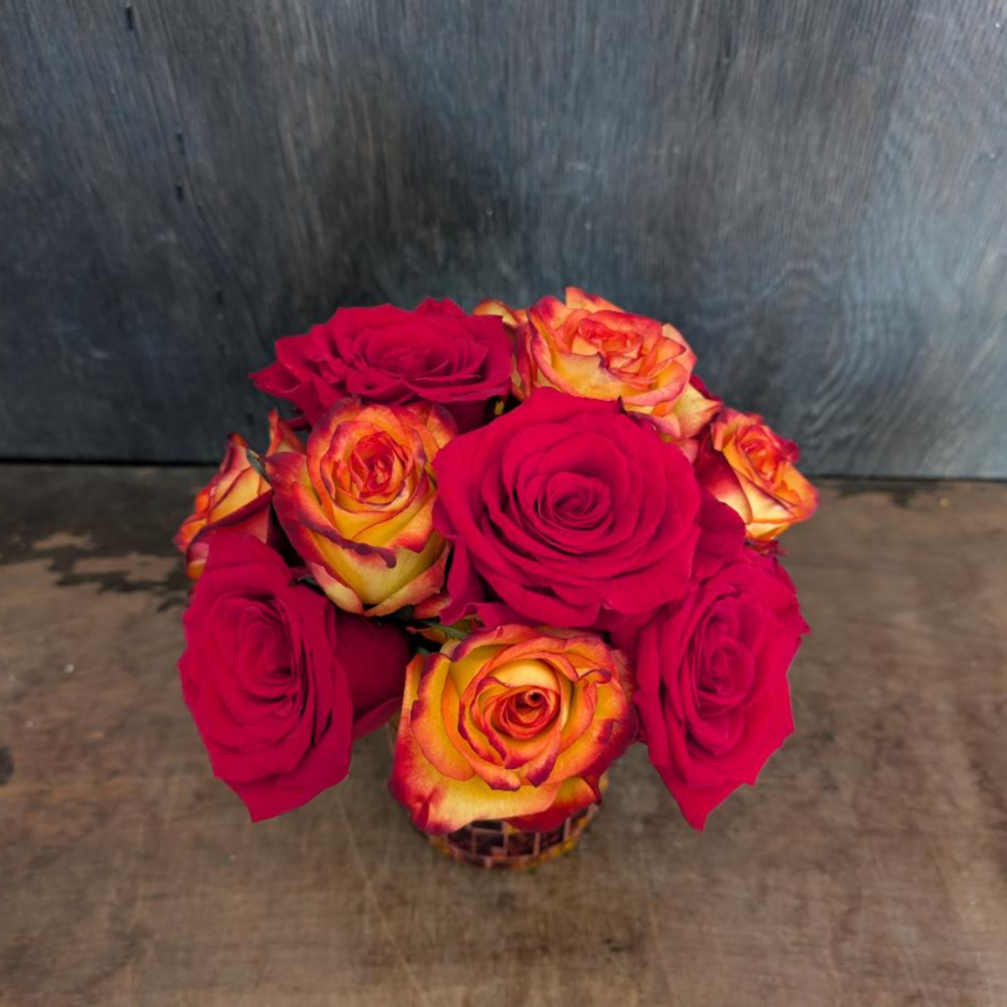 Bouquet of red and orange-yellow roses in a small basket