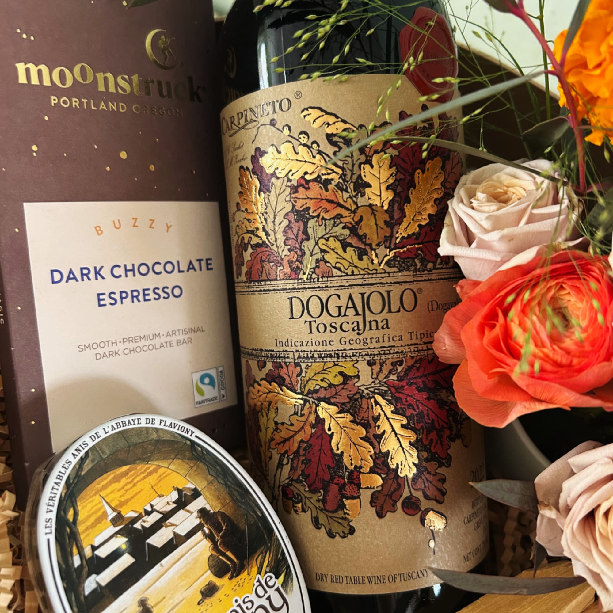Gift set with wine, chocolate, and pink-orange flowers