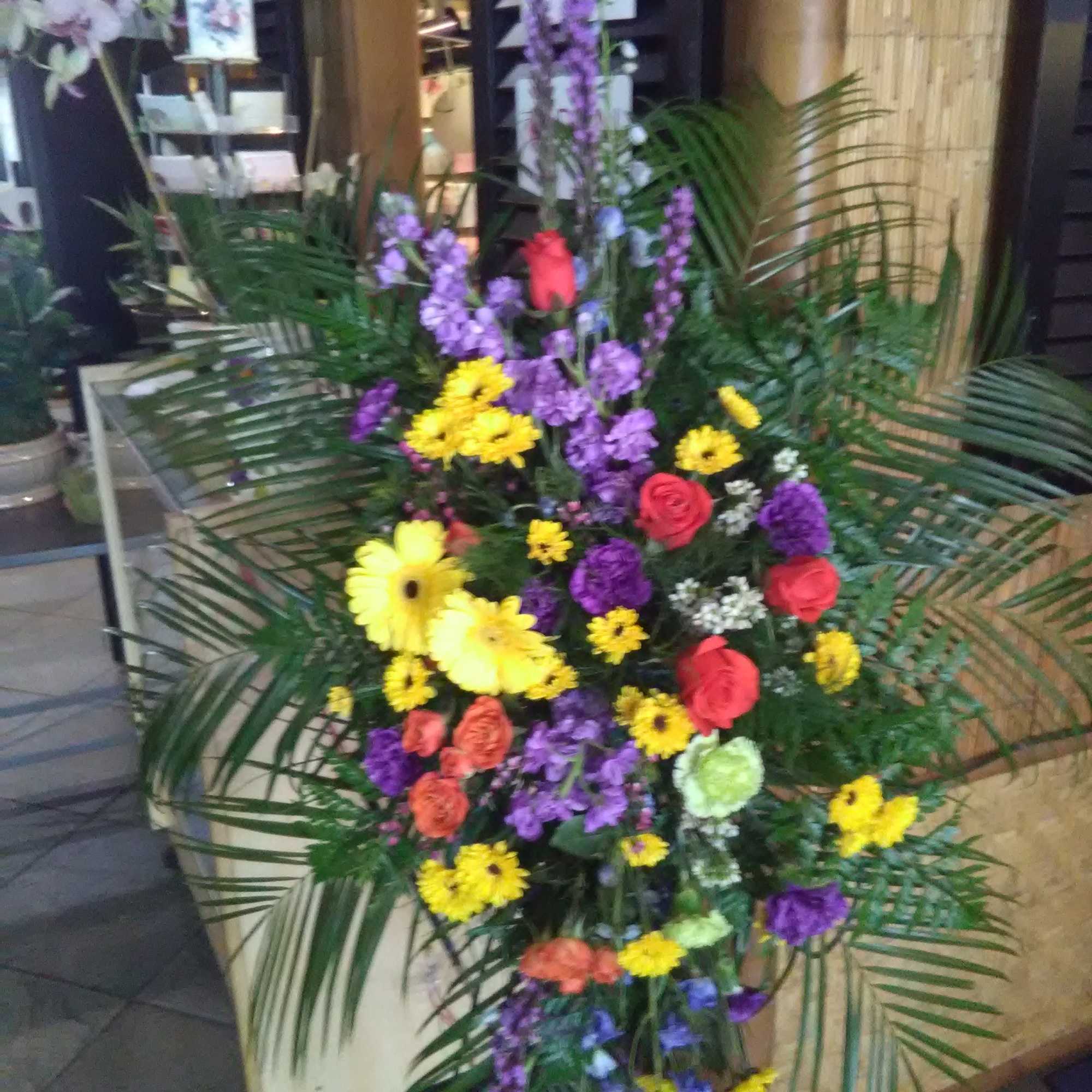 Tall standing floral spray with yellow, purple, and red blooms