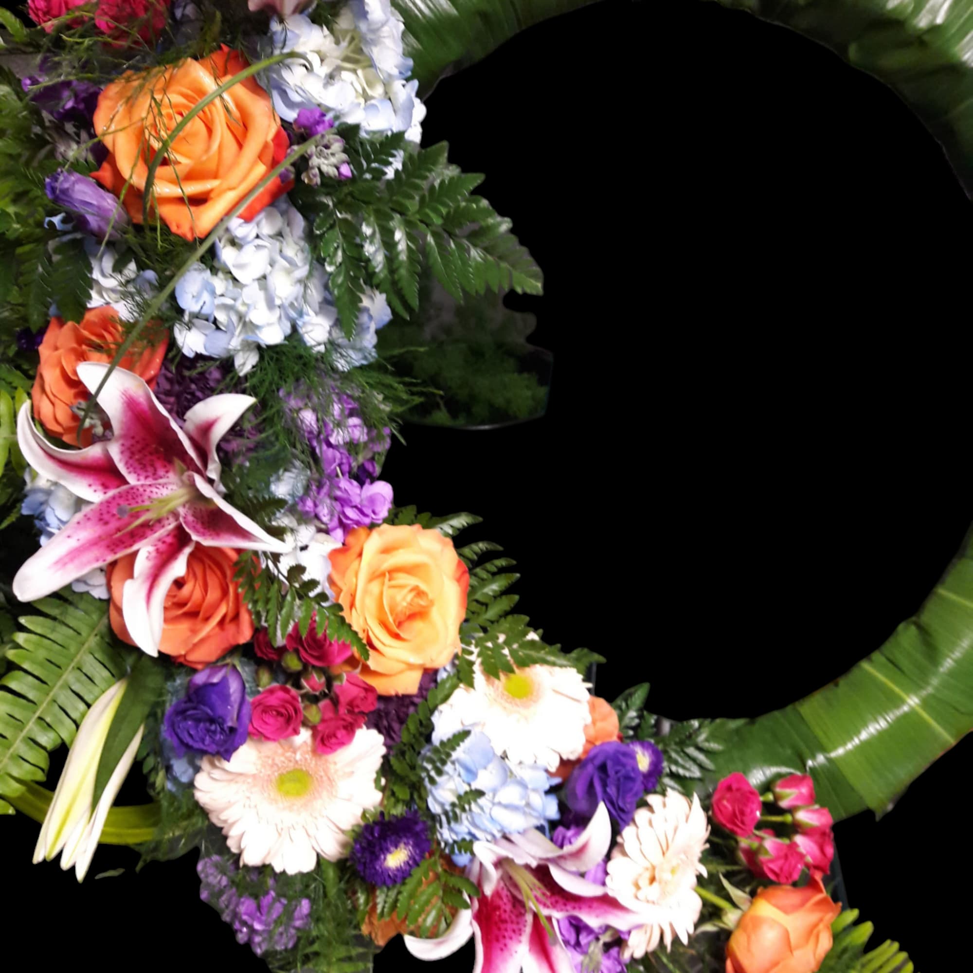 Floral wreath with roses, lilies, and hydrangeas on a green ring
