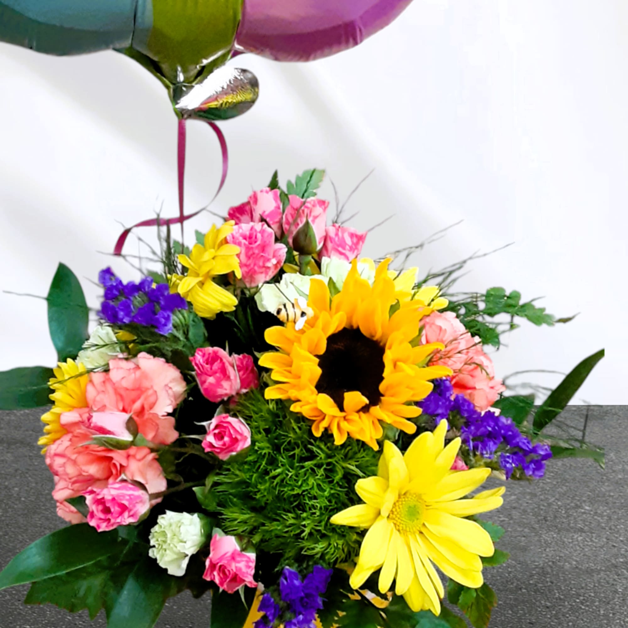 Colorful bouquet with sunflowers, carnations, and a balloon