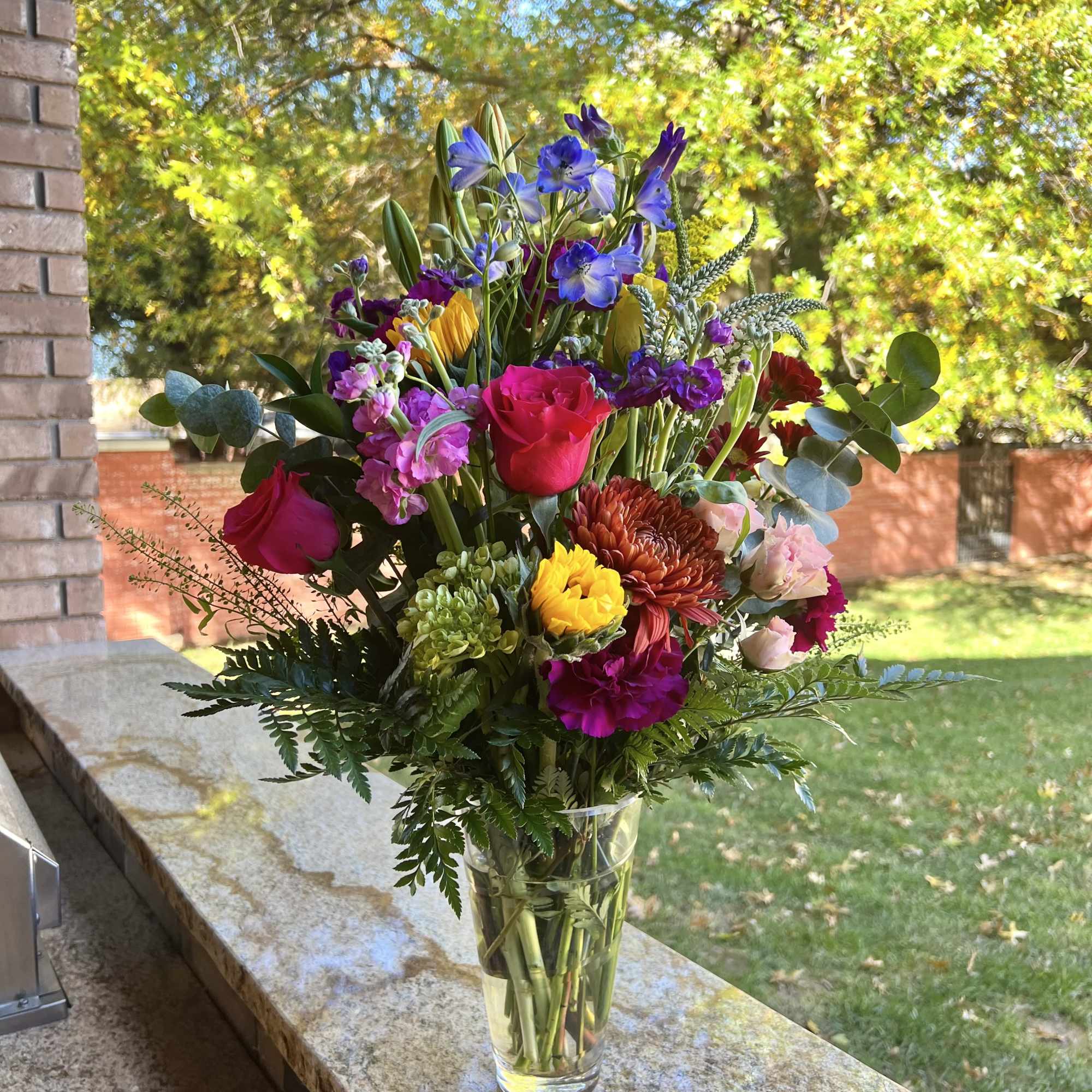 Mixed bouquet of colorful flowers in a clear glass vase