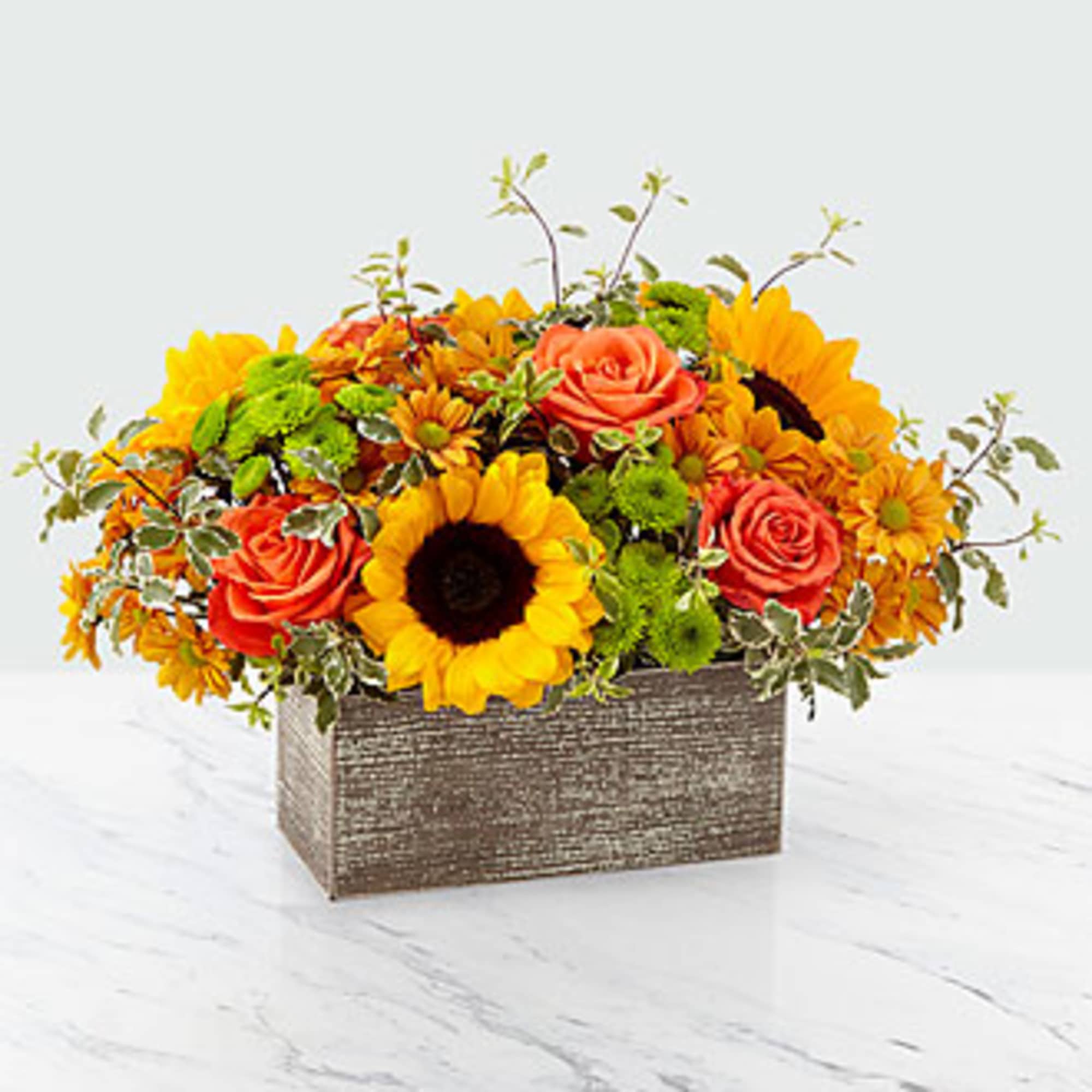 Sunflower and orange rose arrangement in a rectangular textured container
