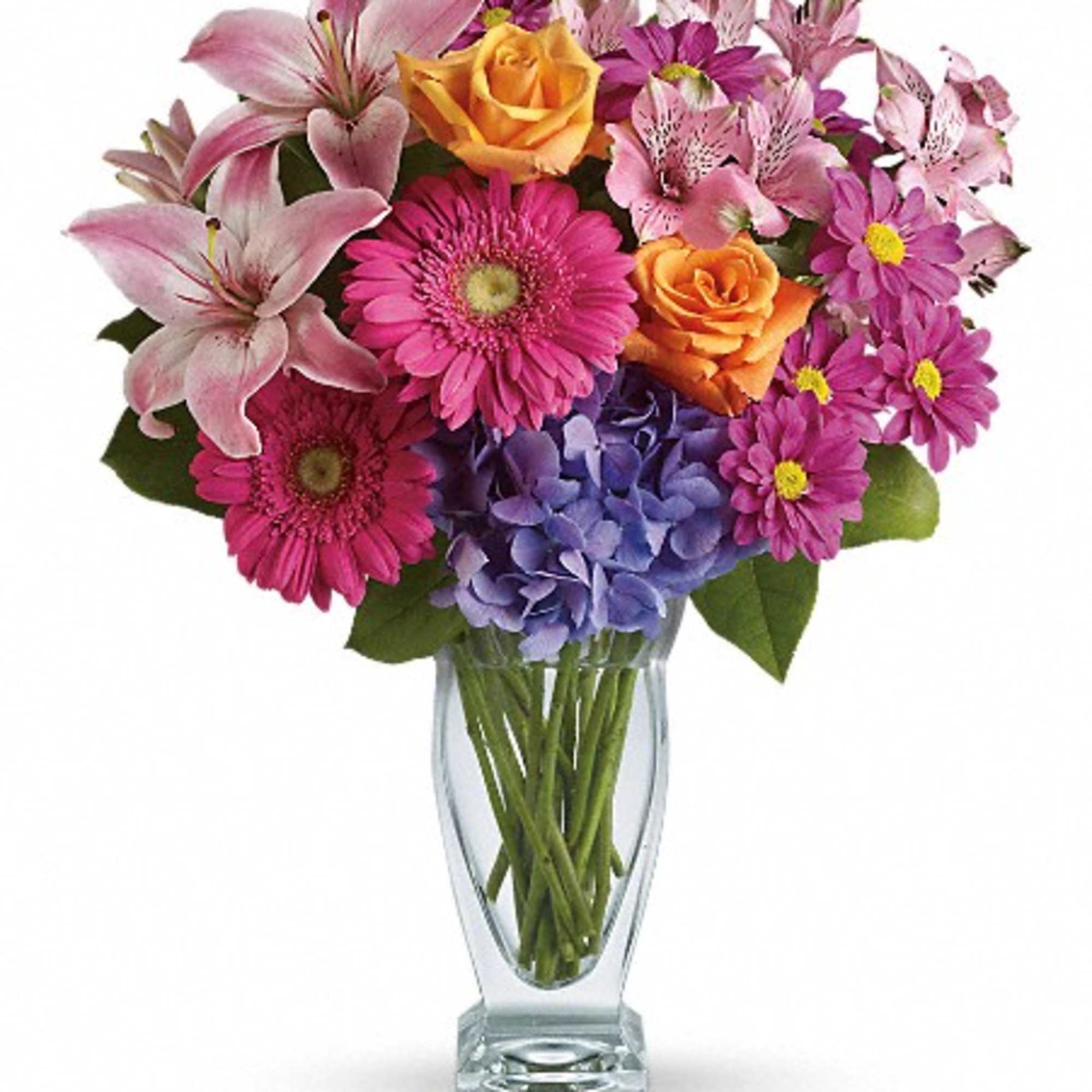 Mixed bouquet of lilies, roses, gerbera daisies, hydrangea, and daisies in a glass vase