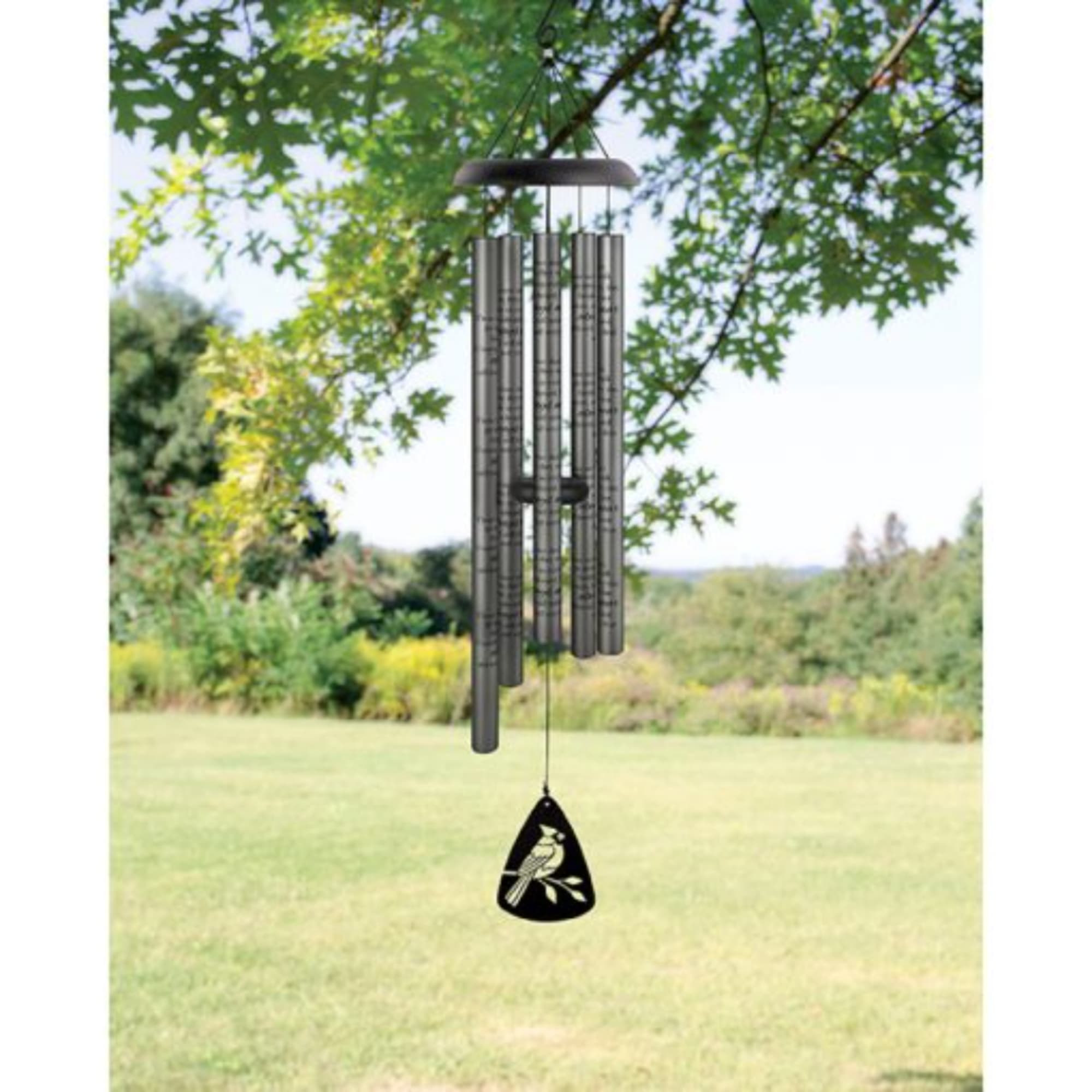 A metal wind chime hangs outdoors with a bird-shaped pendant.