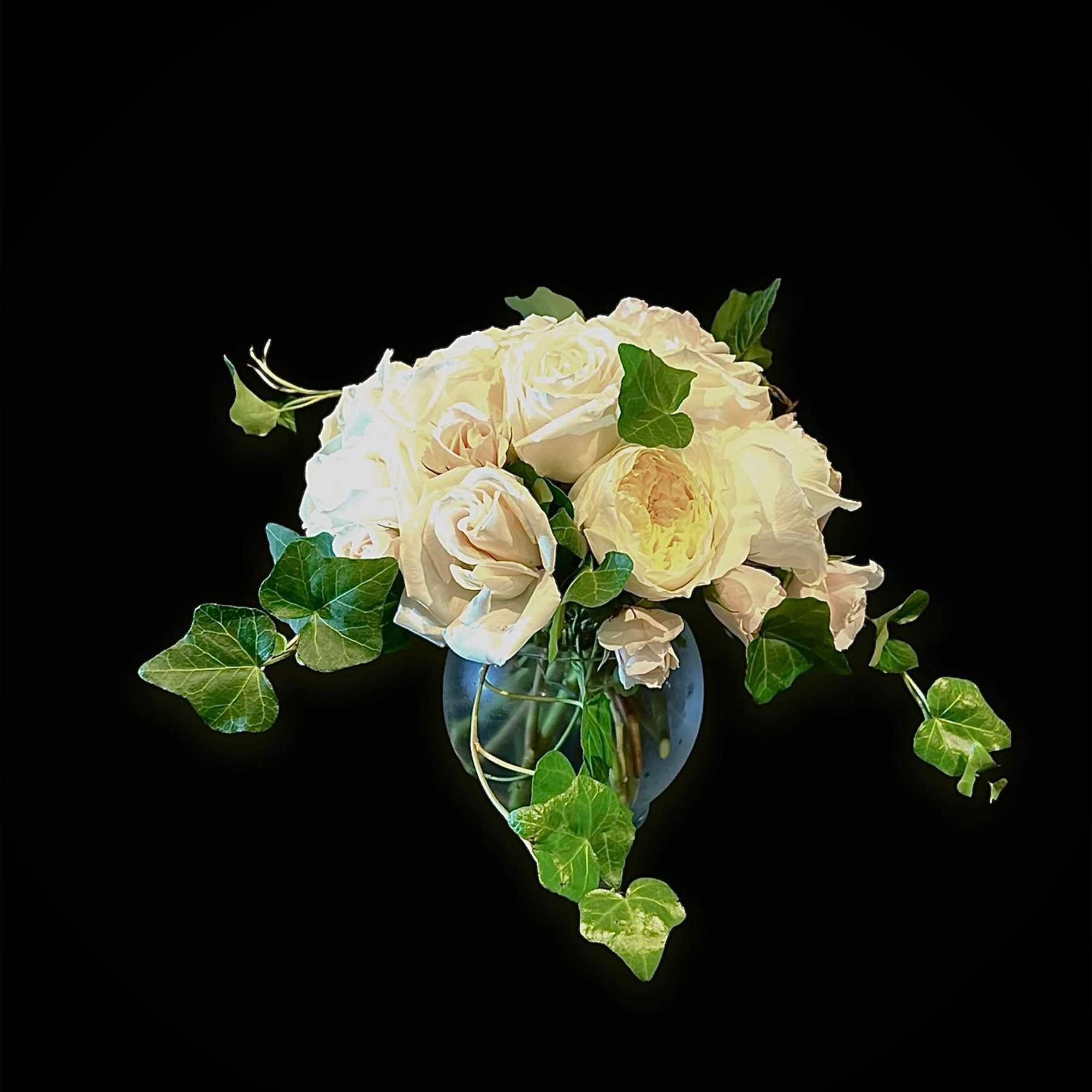 White rose bouquet in a glass vase with trailing ivy