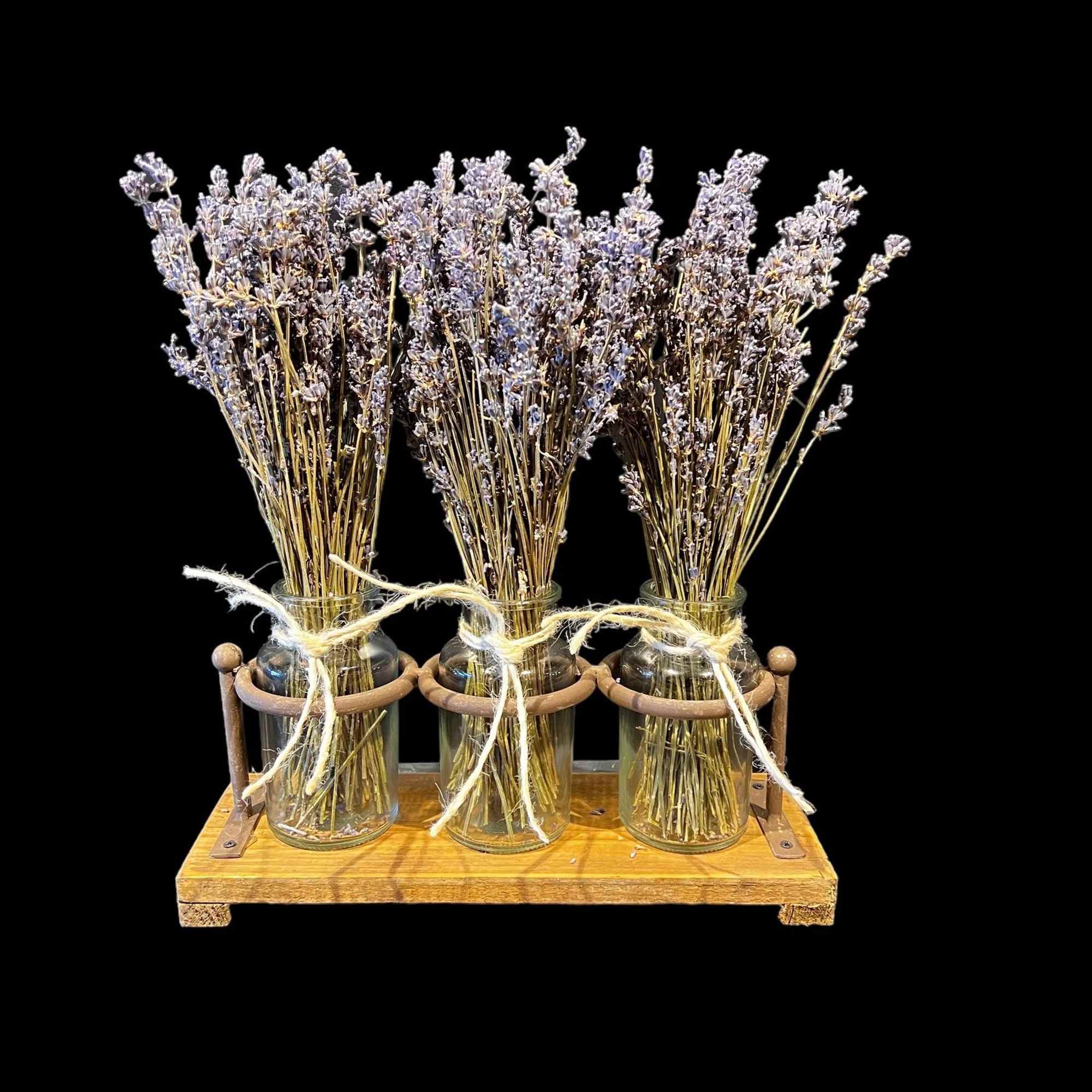 Three jars of dried lavender tied with twine on a wooden tray