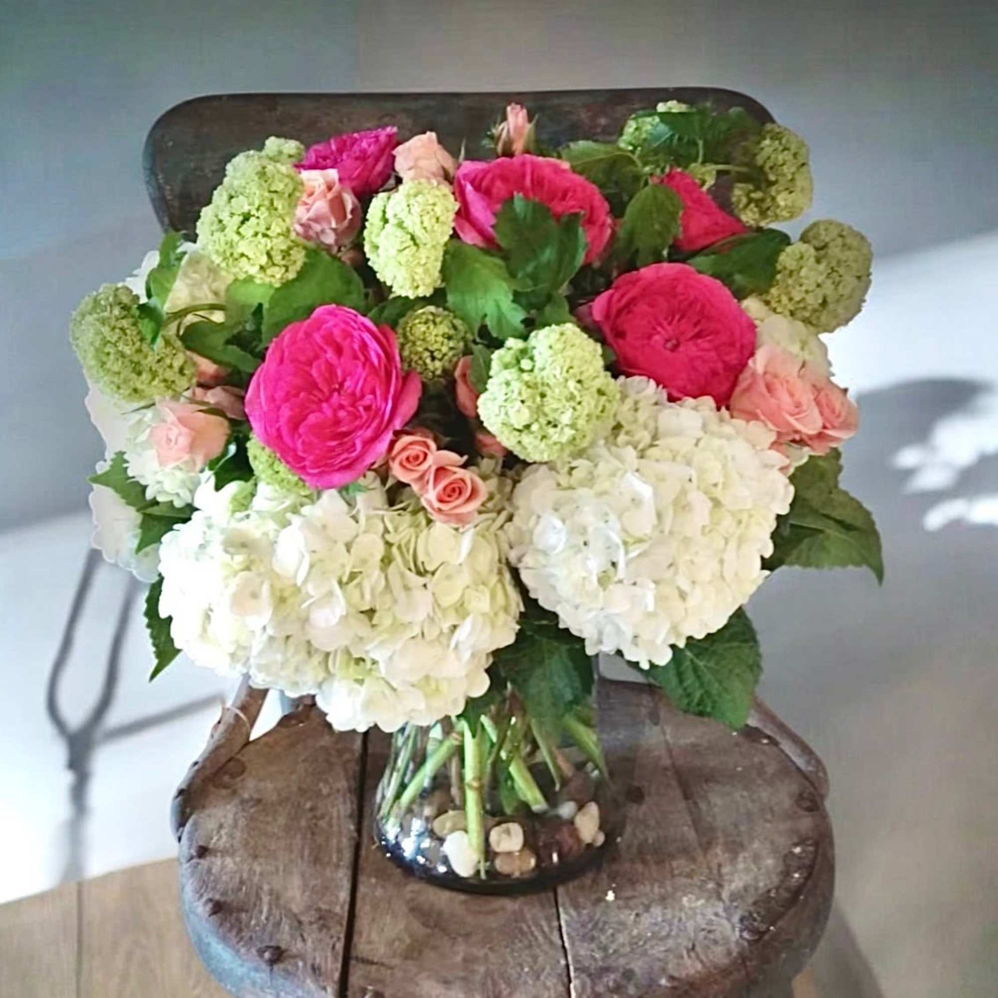 Bouquet of pink roses and white hydrangeas in a glass vase