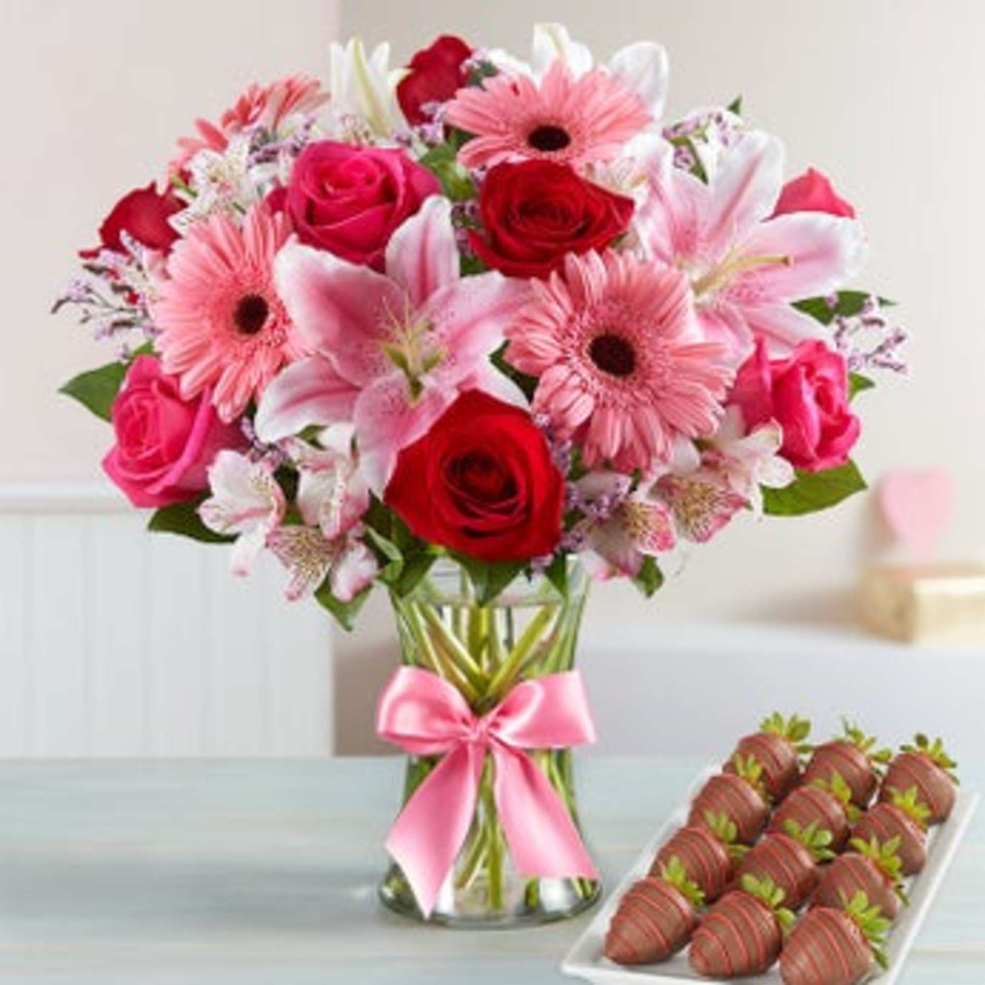 Pink and red mixed bouquet in a glass vase with a pink ribbon, photo 2 of 3