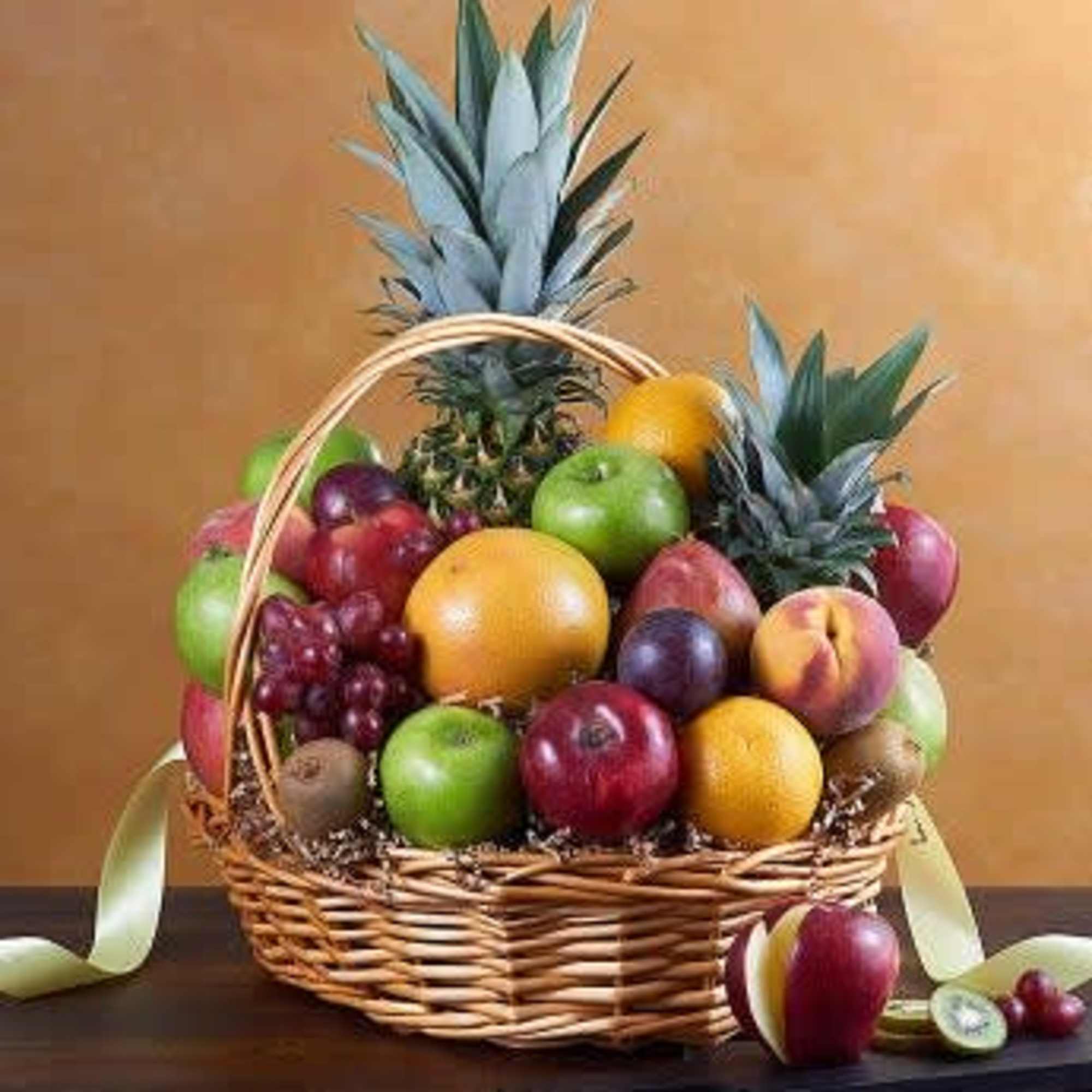 Fruit basket with pineapples, apples, oranges, grapes, and peaches