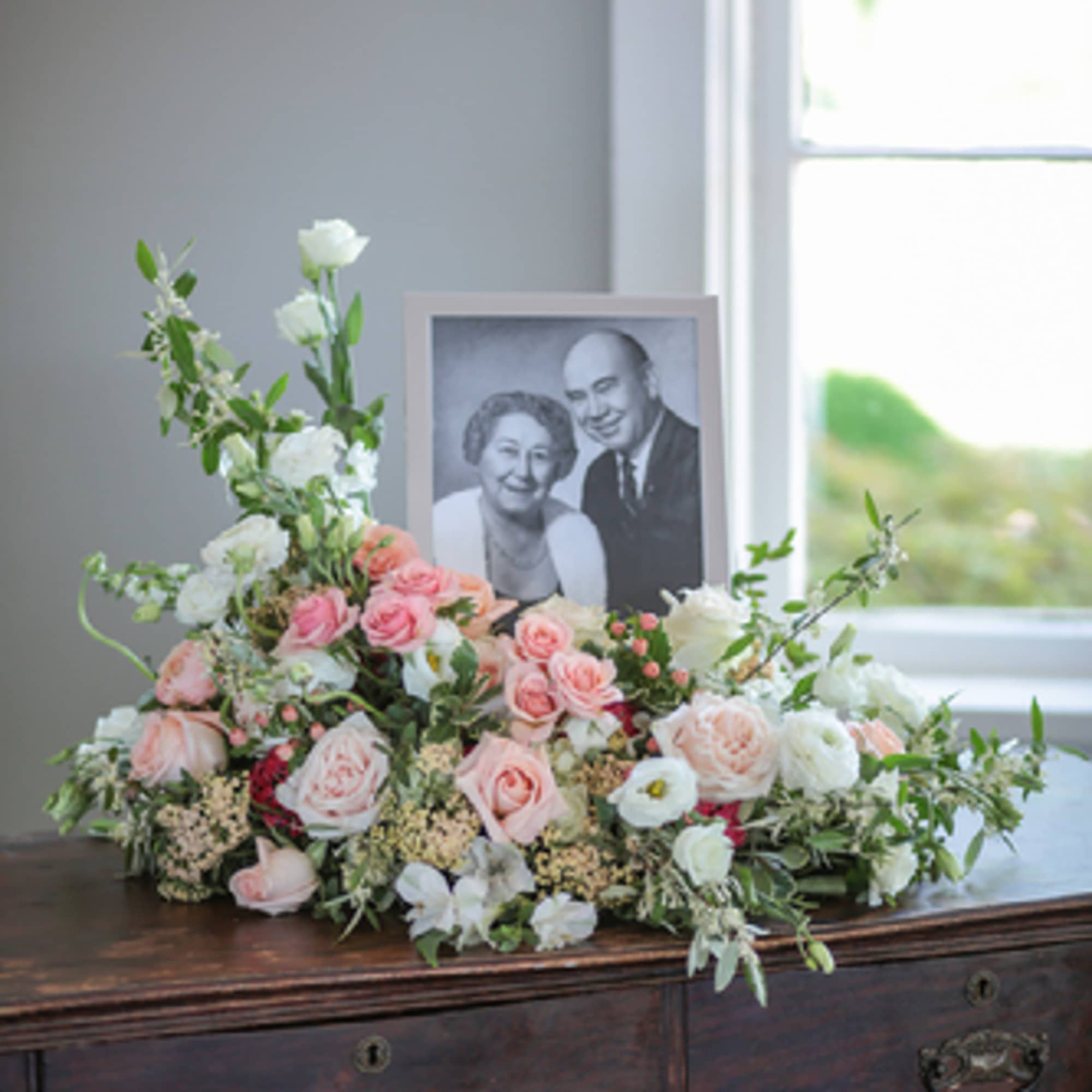 Pastel floral arrangement with a framed black-and-white portrait