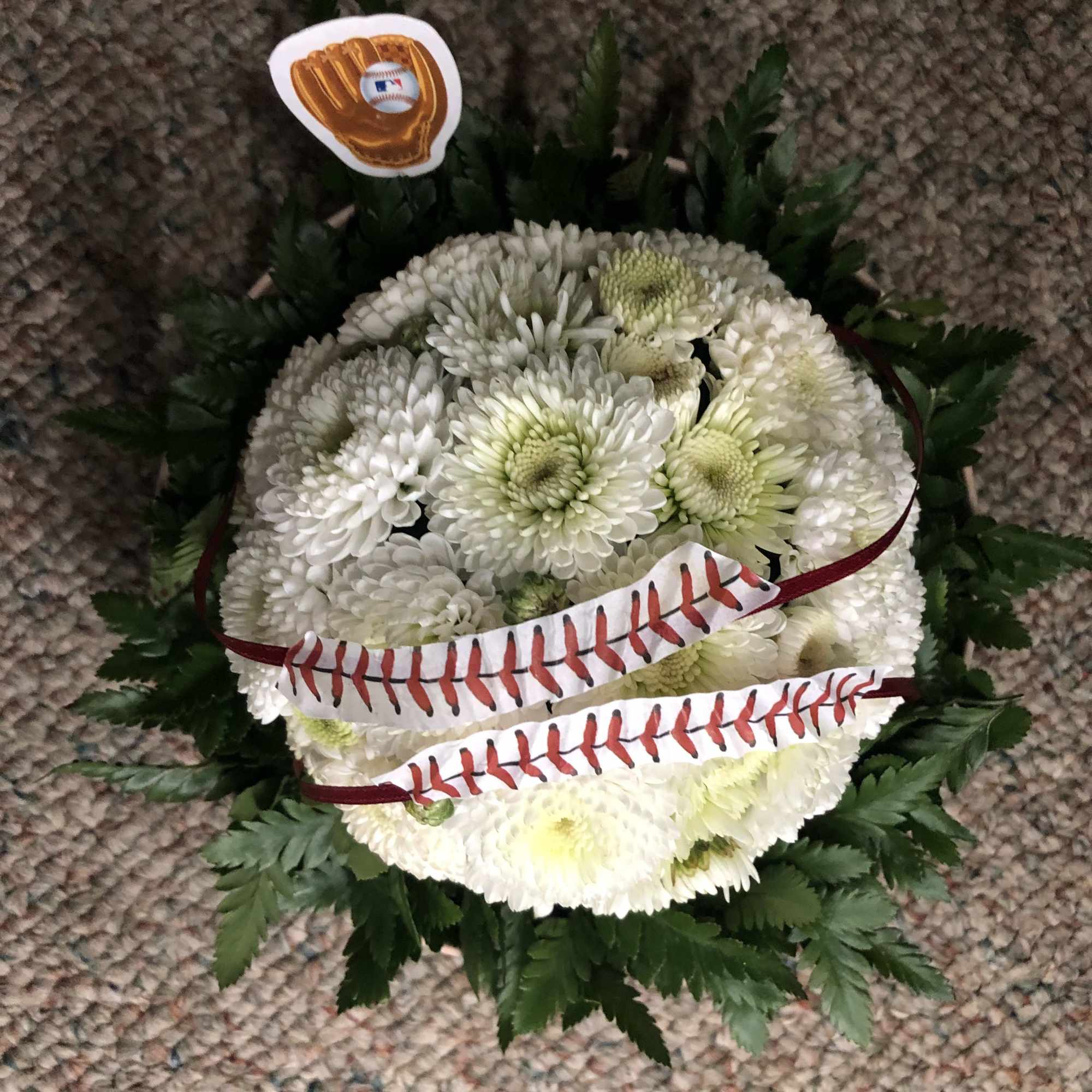 White chrysanthemum arrangement with baseball decorations