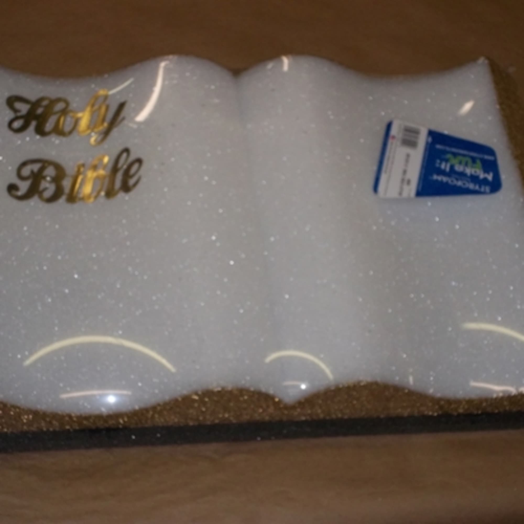 White glittery Holy Bible with gold lettering in plastic packaging