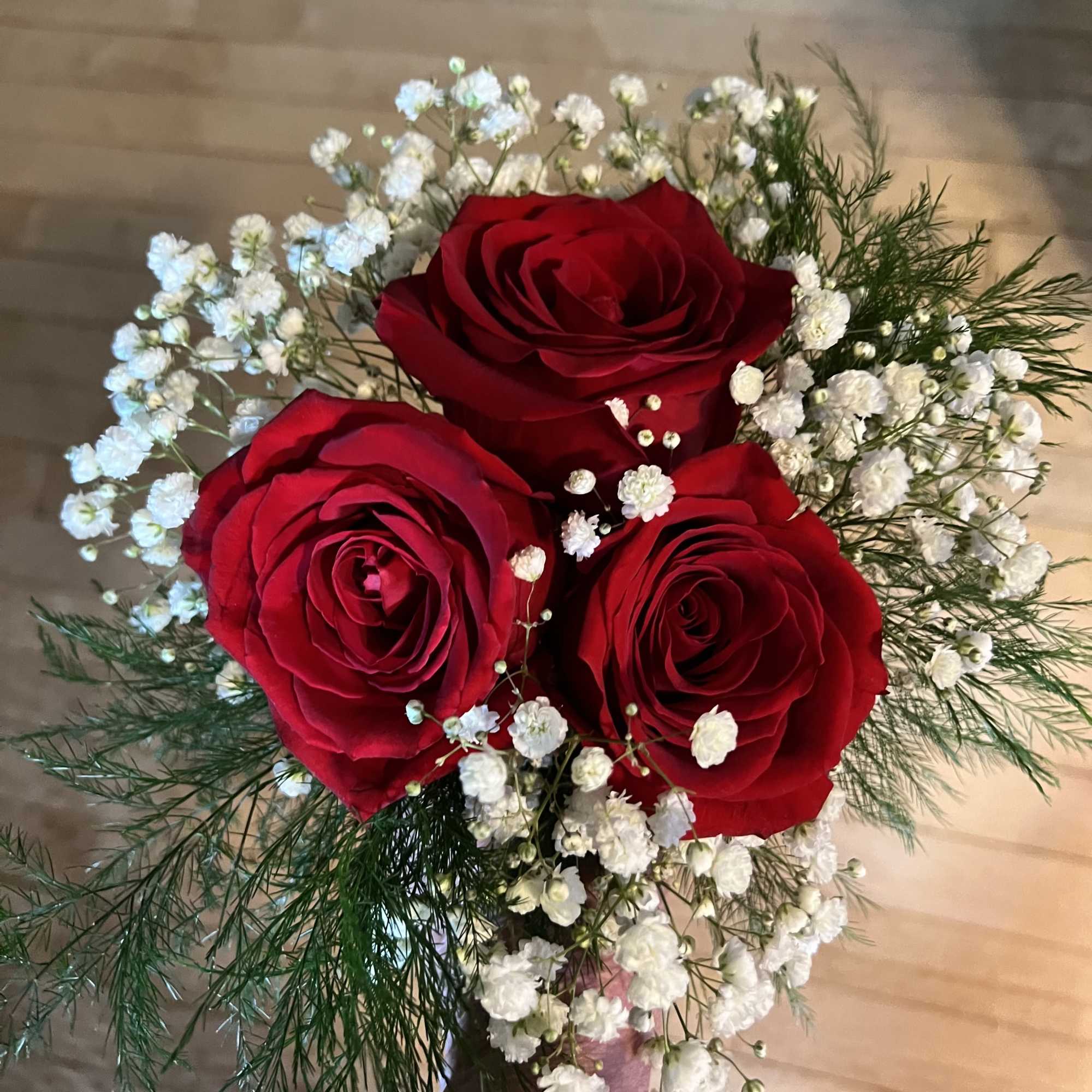 Bouquet of red roses with white baby's breath in a wrapped handle