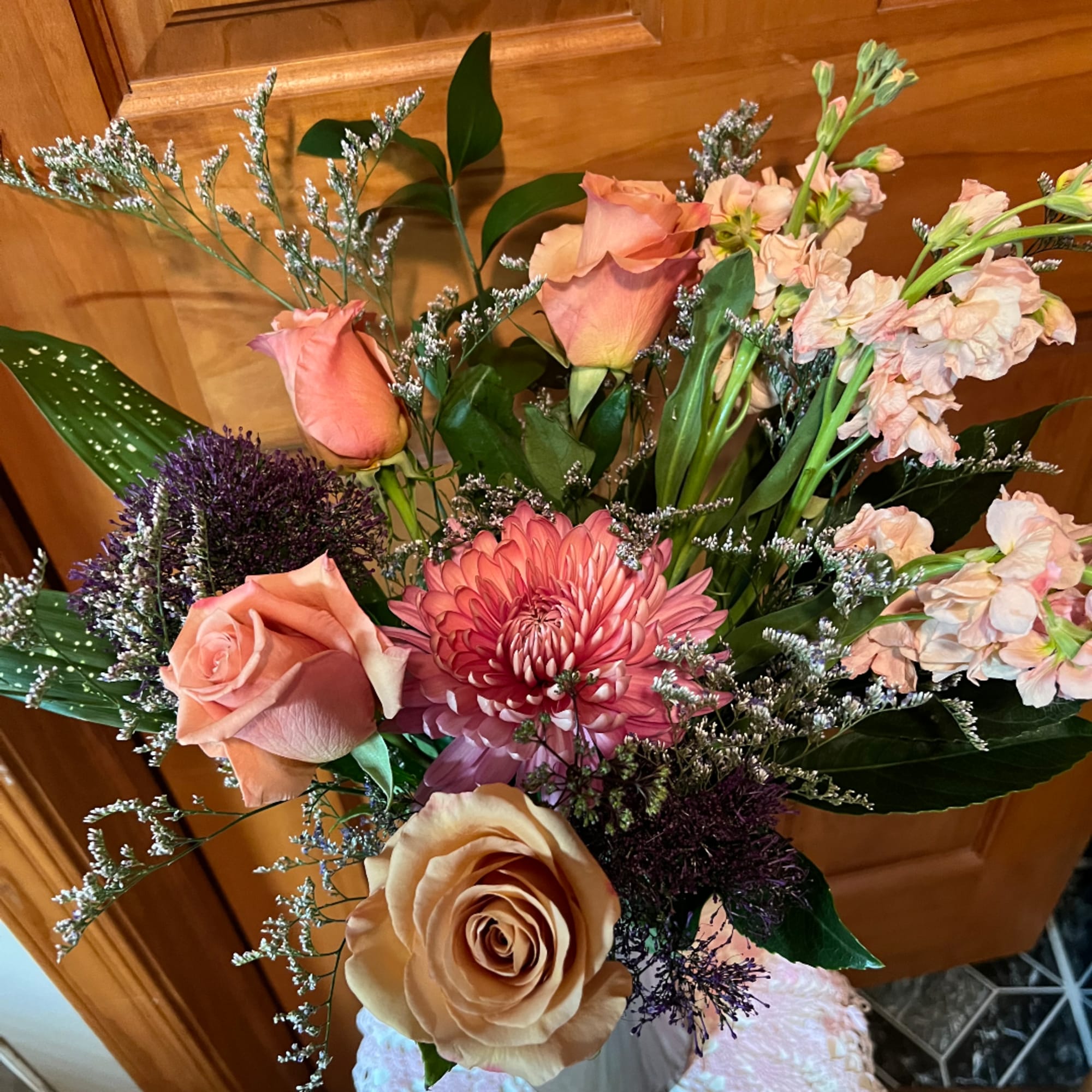Peach and pink mixed bouquet with roses, a chrysanthemum, and pale stock