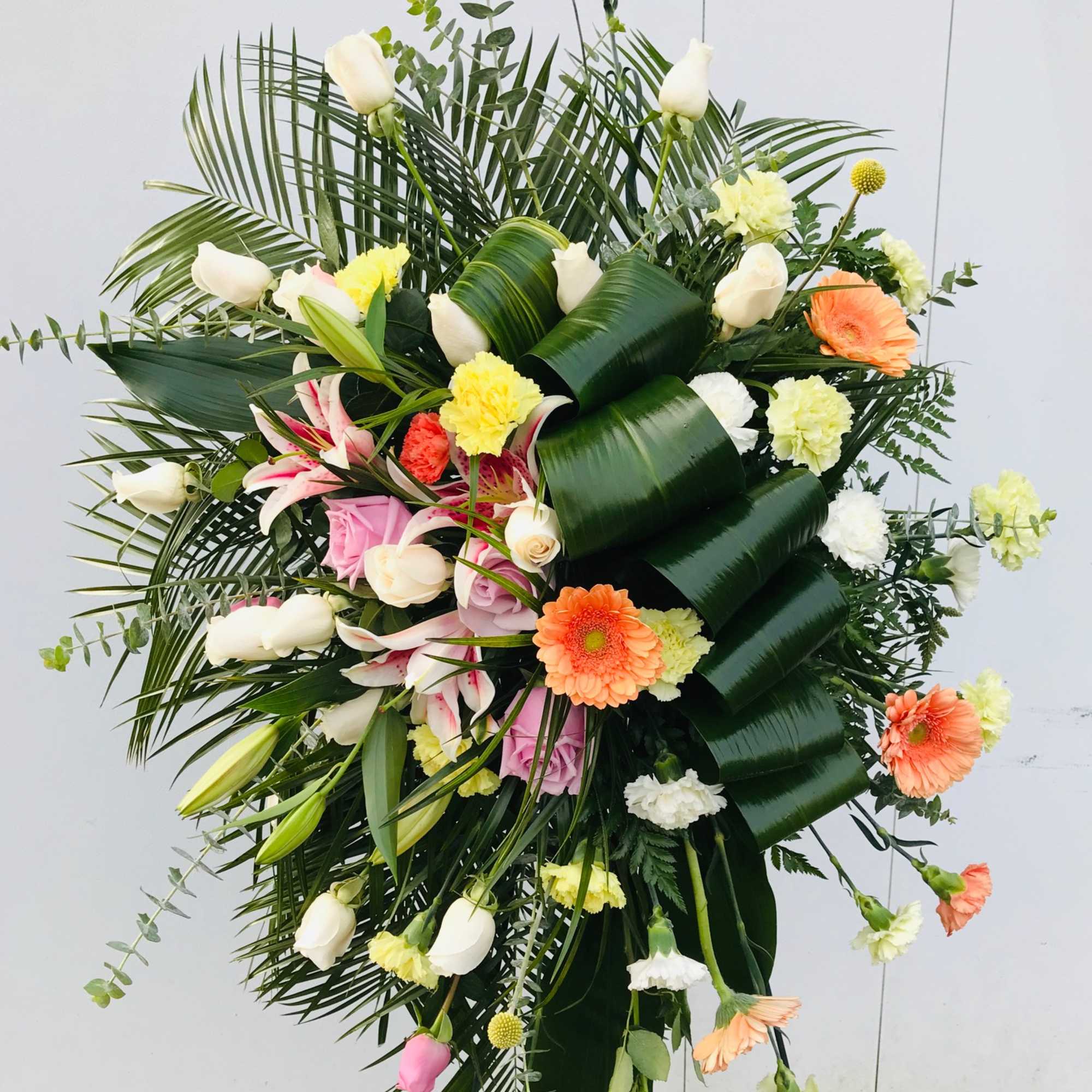 Large standing floral spray with white, pink, and orange flowers