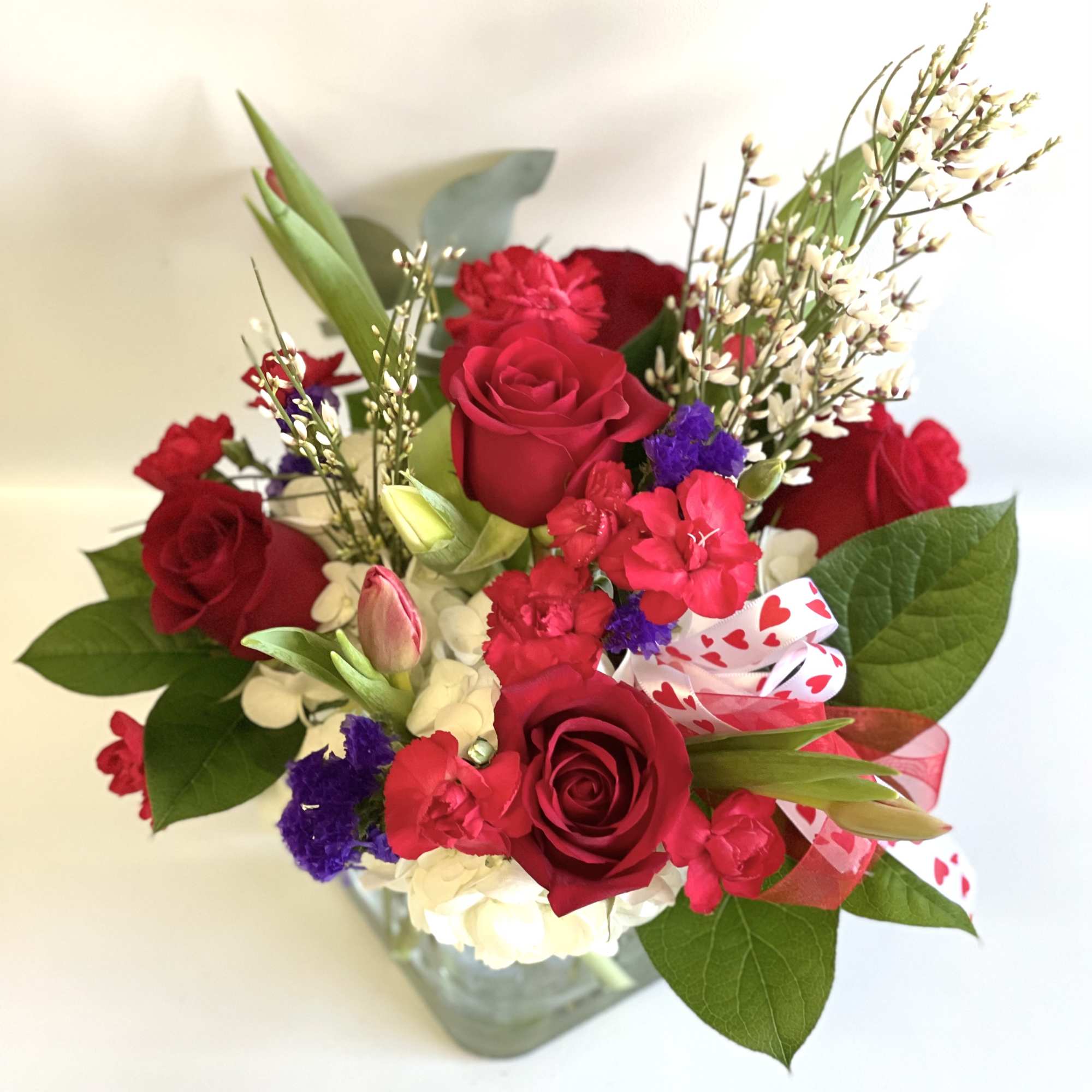 Bouquet of red roses and mixed flowers in a glass vase