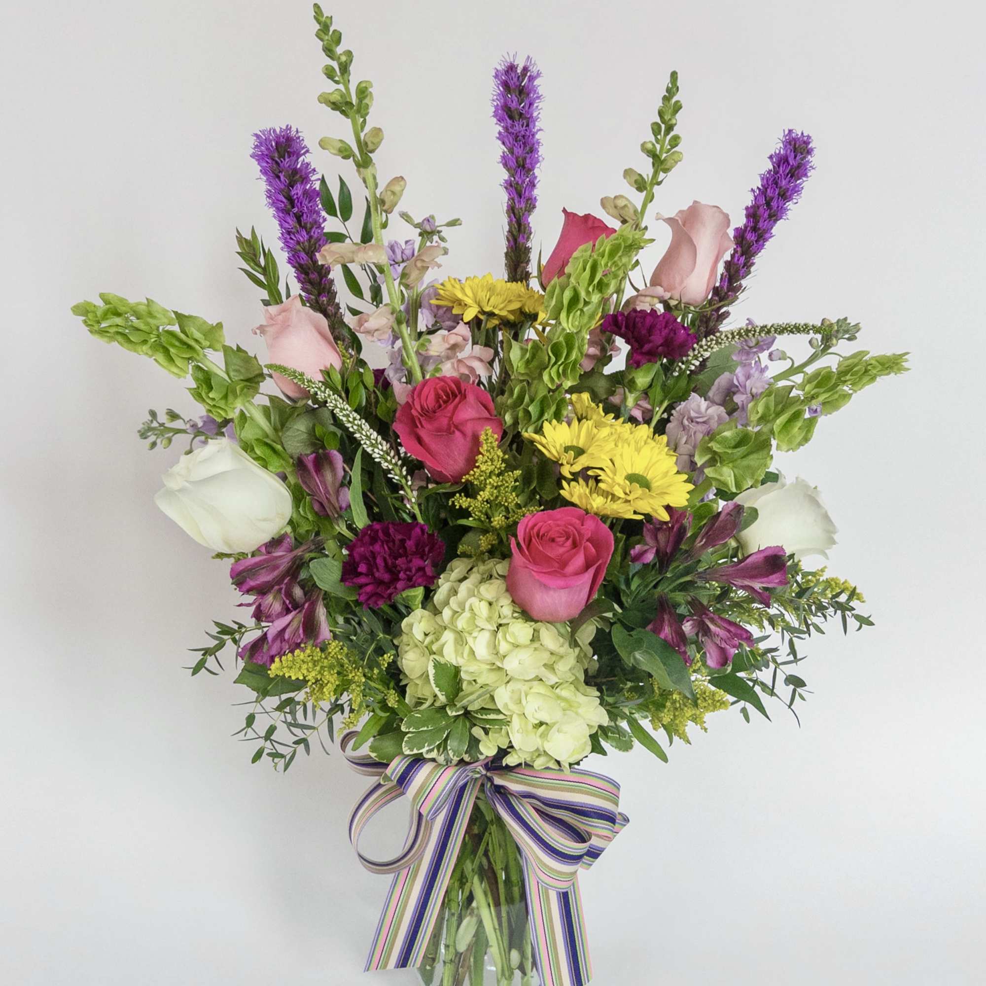 Mixed bouquet in a glass vase with pink, white, yellow, and purple flowers