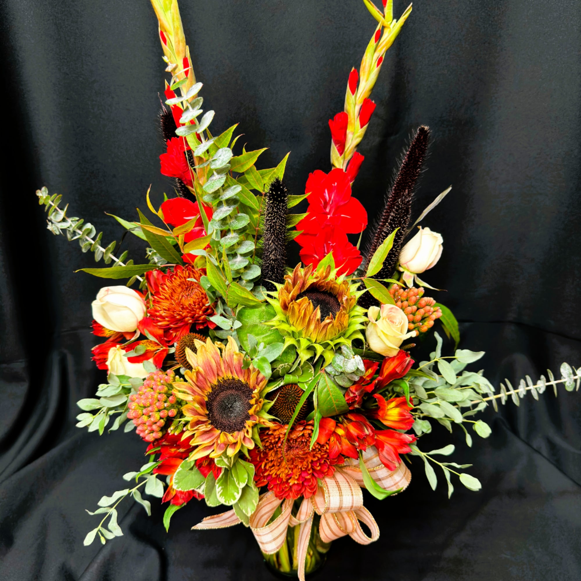 Bright mixed bouquet with sunflowers, red blooms, and white roses in a vase
