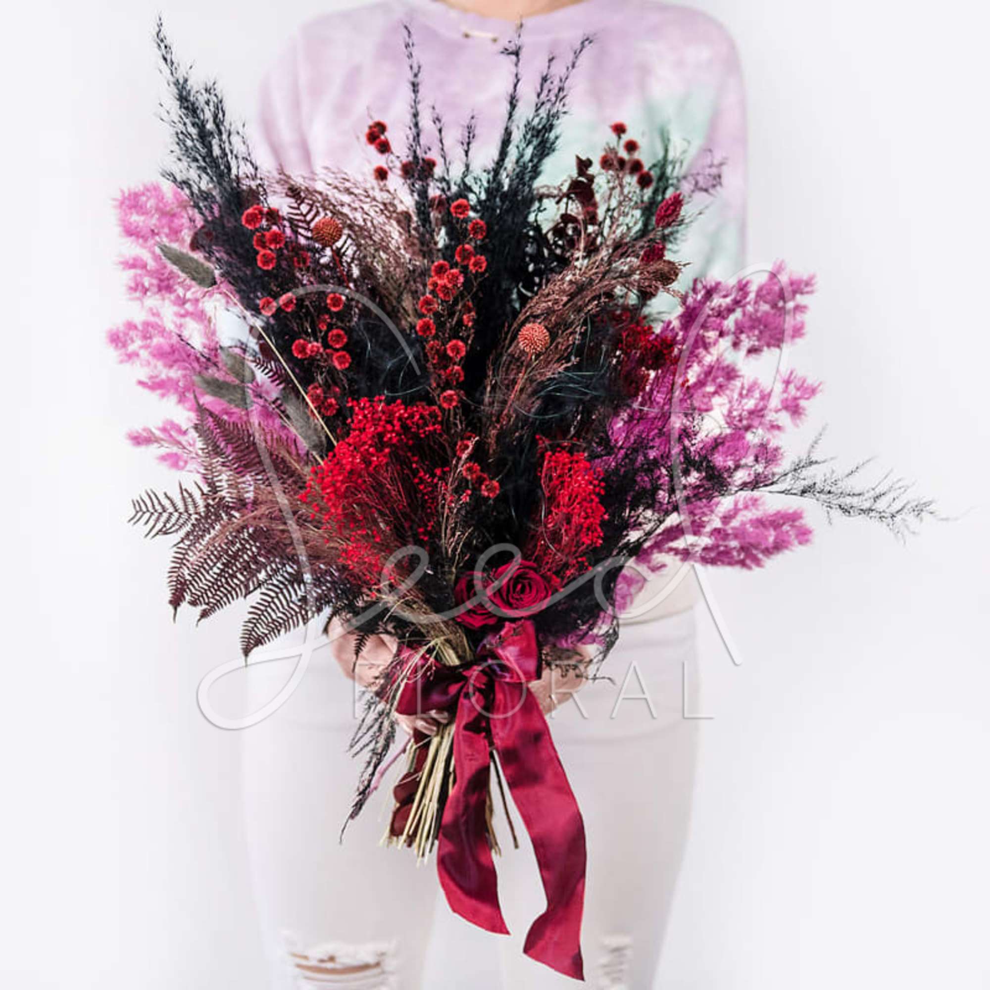 Large bouquet of red and pink flowers with a satin ribbon