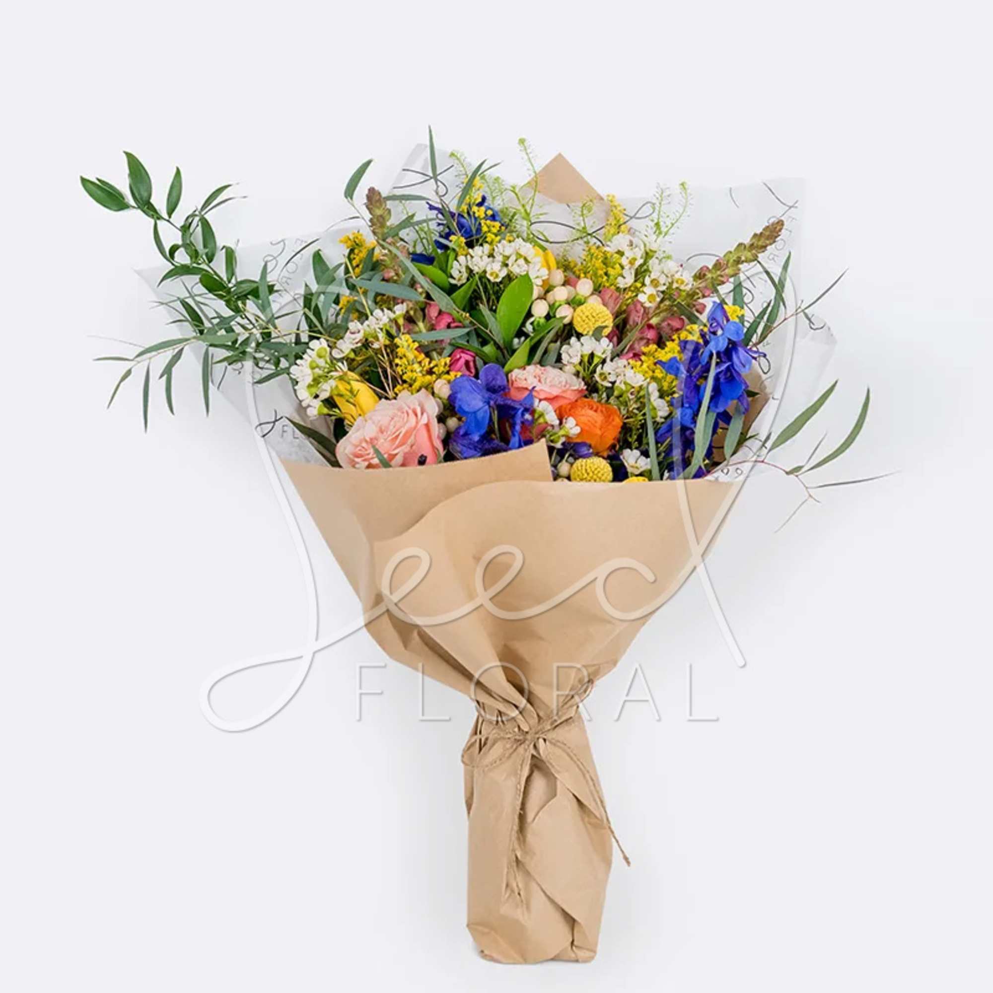 Mixed bouquet with pink, orange, blue, and yellow flowers wrapped in brown paper