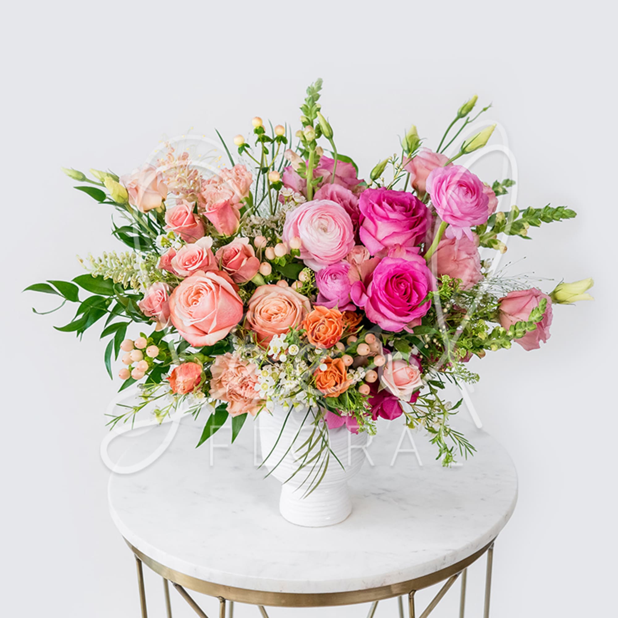 Pink and peach rose bouquet in a white vase