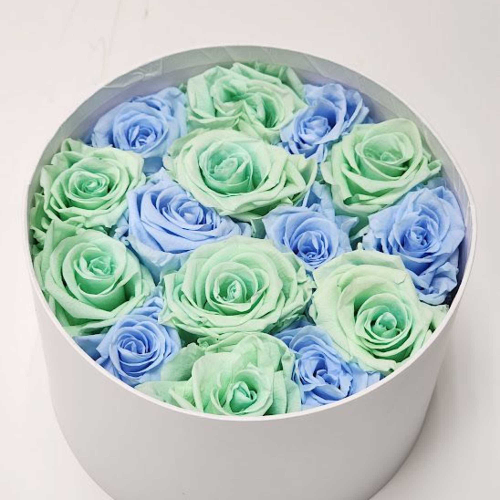 Round box of pastel blue and mint roses