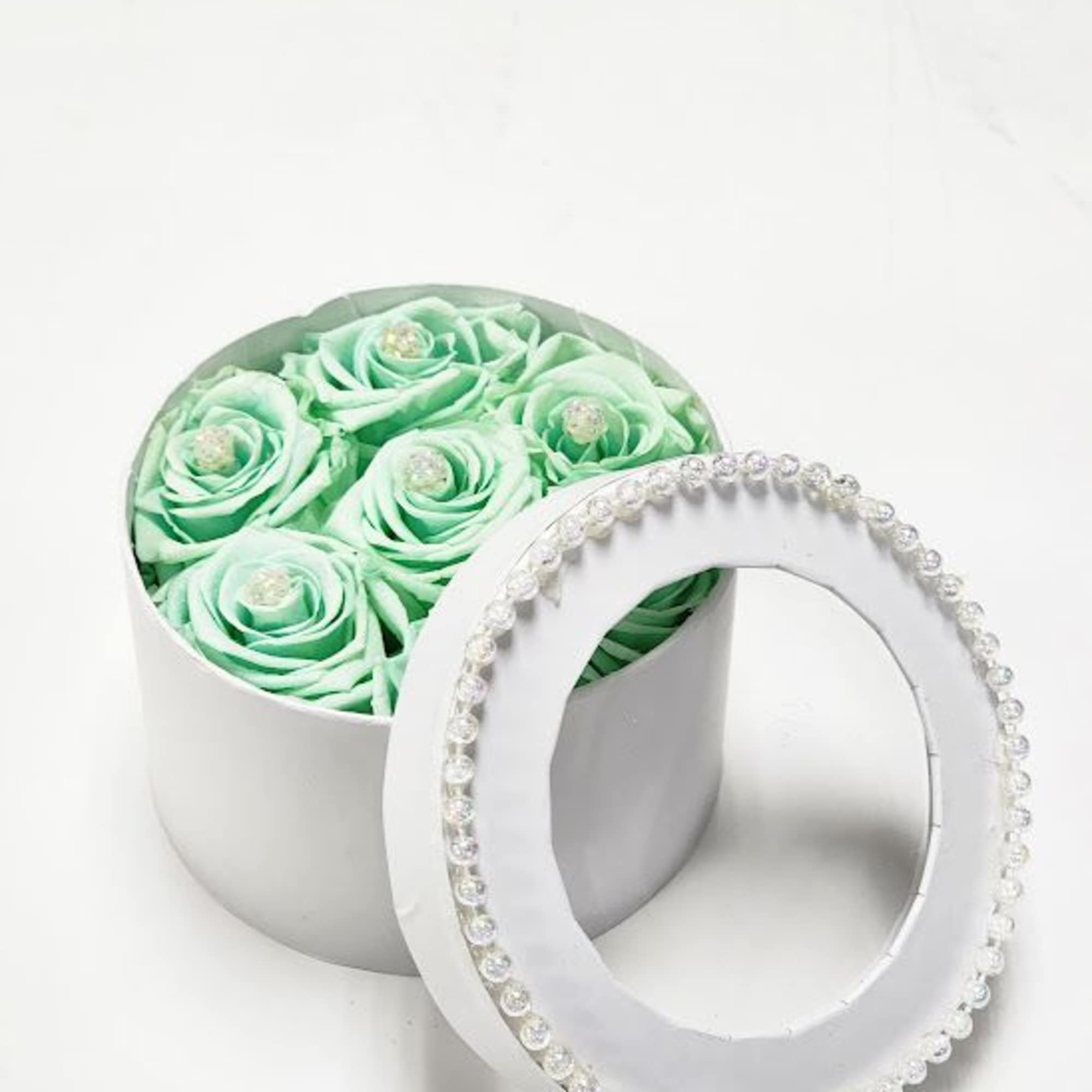 Mint green roses in a round white box with a beaded lid