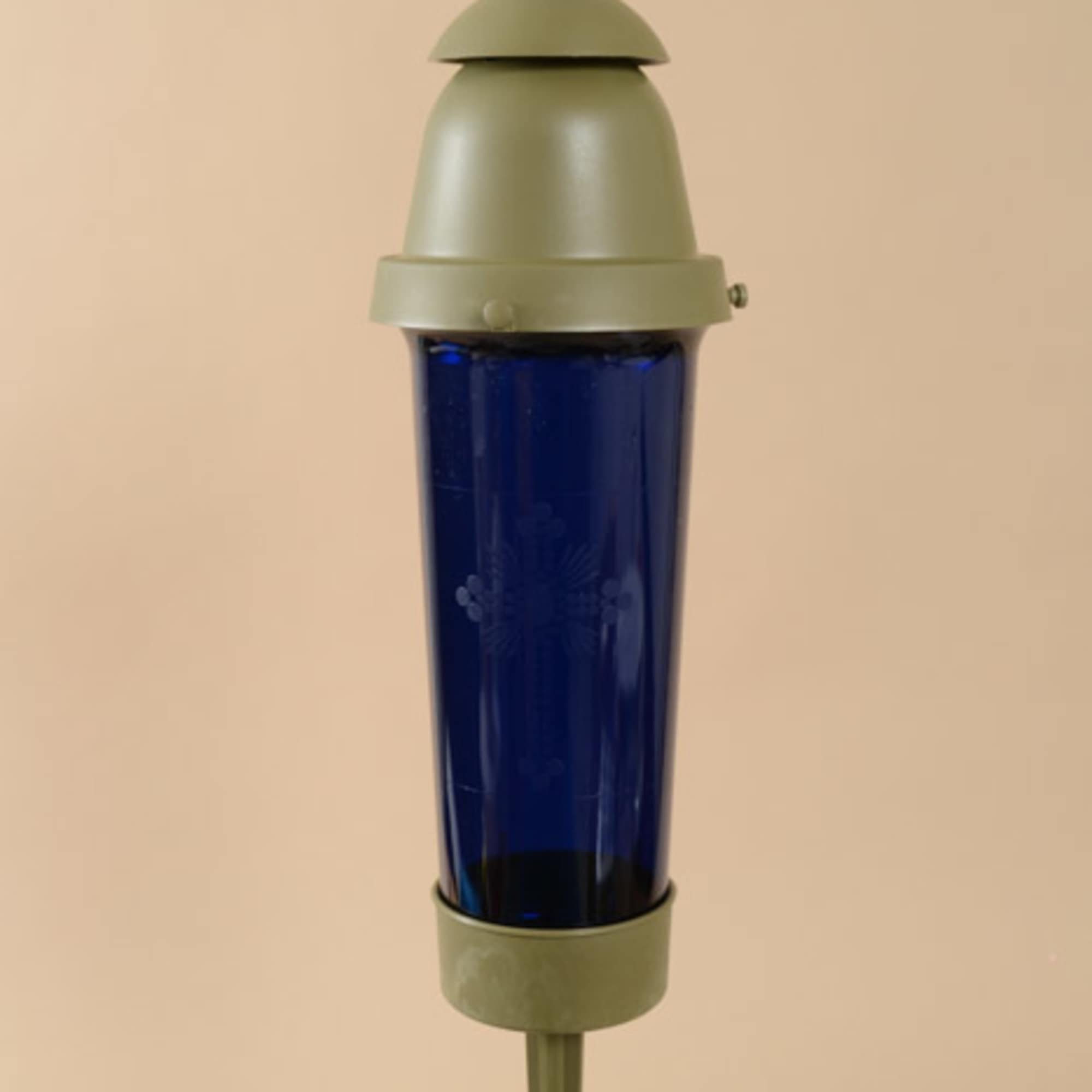 Blue glass memorial candle with a cross topper