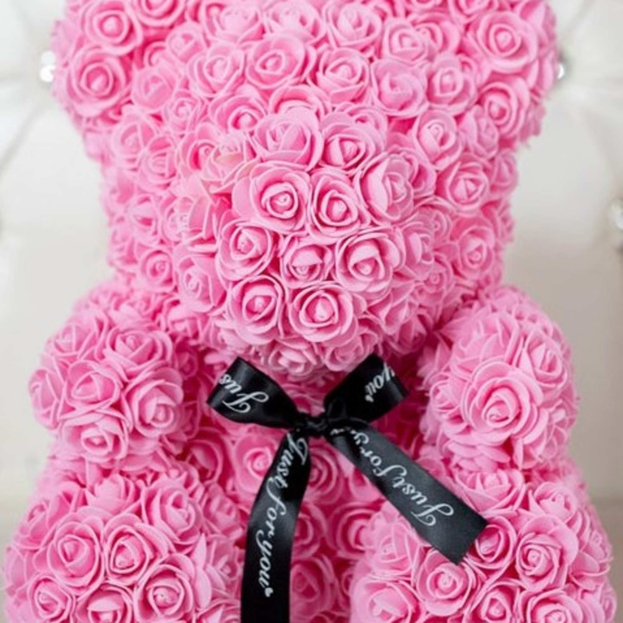 Pink rose teddy bear with a black ribbon bow