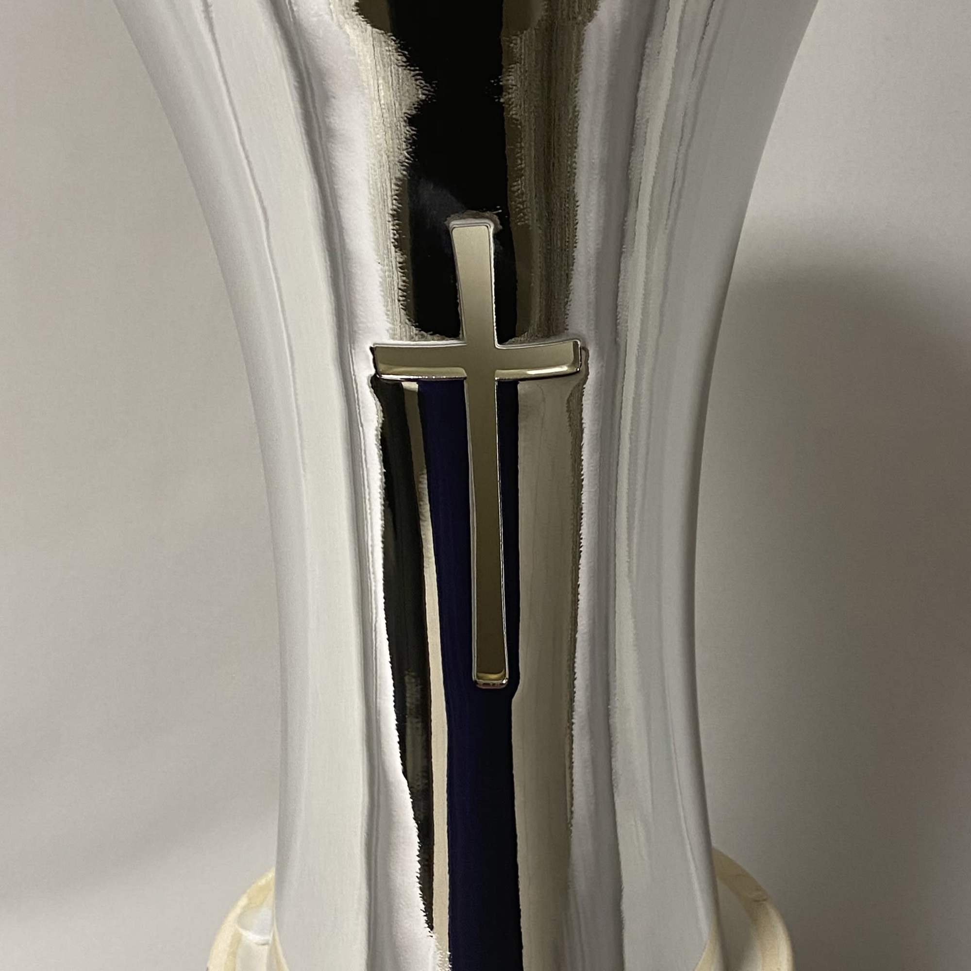 Silver vase with a cross emblem on a white base
