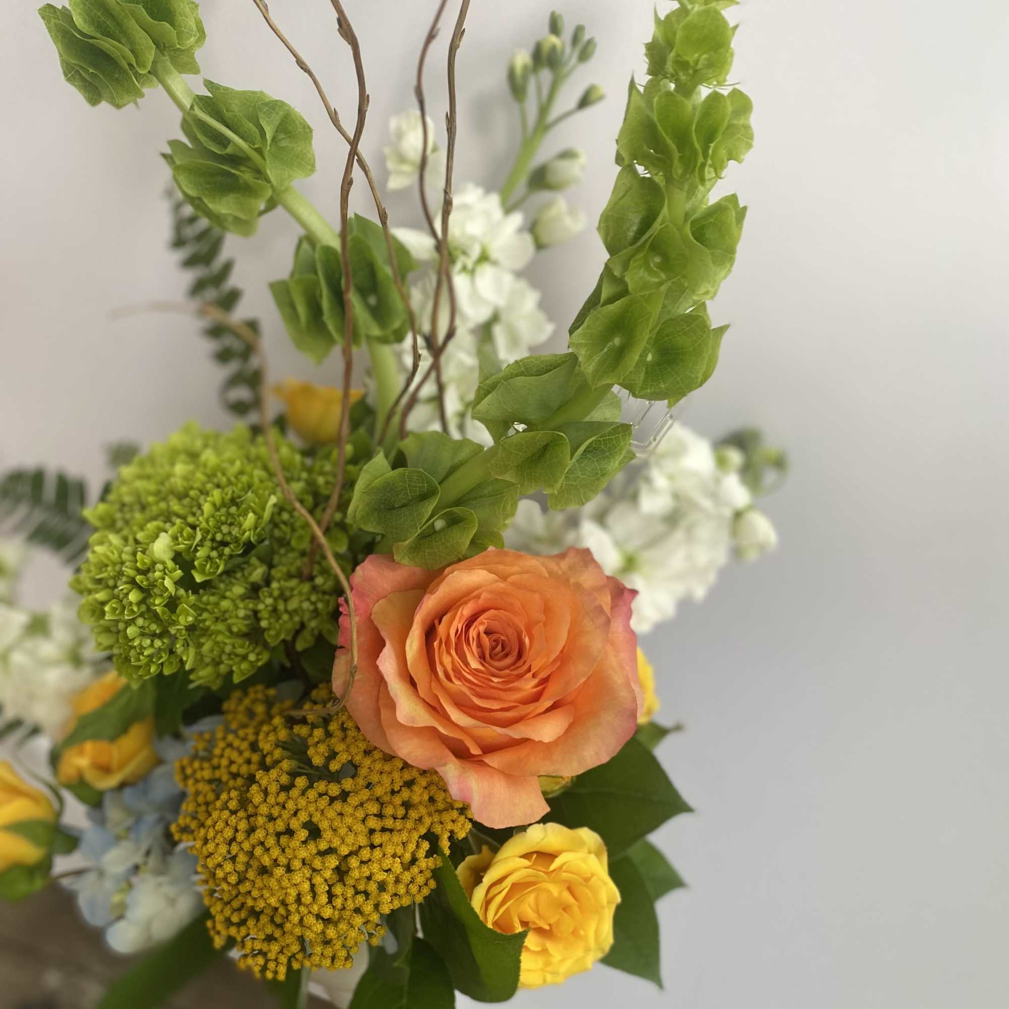 Mixed bouquet with orange and yellow roses and green blooms