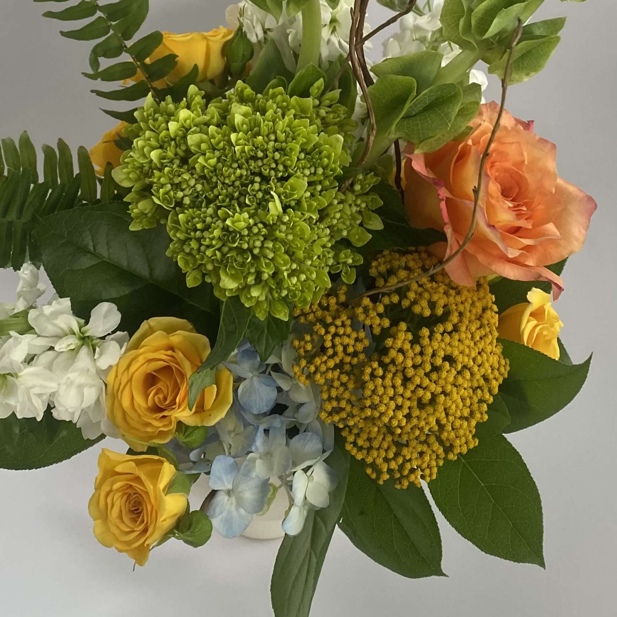 Bouquet of yellow and peach roses with green and white blooms