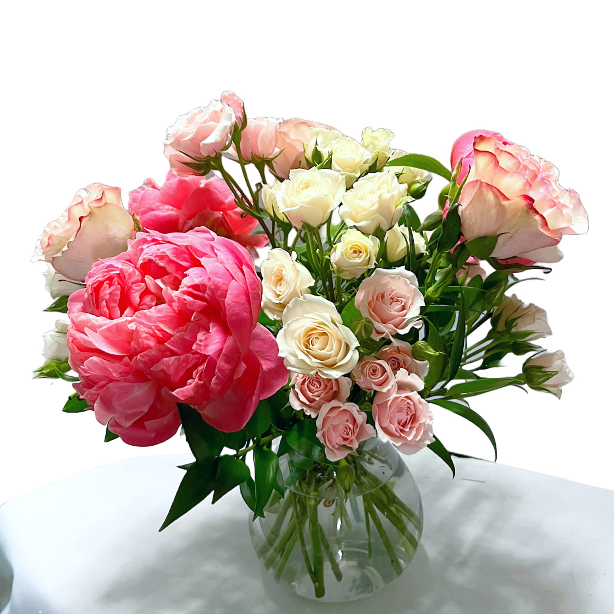 Pink and white rose bouquet in a clear glass vase