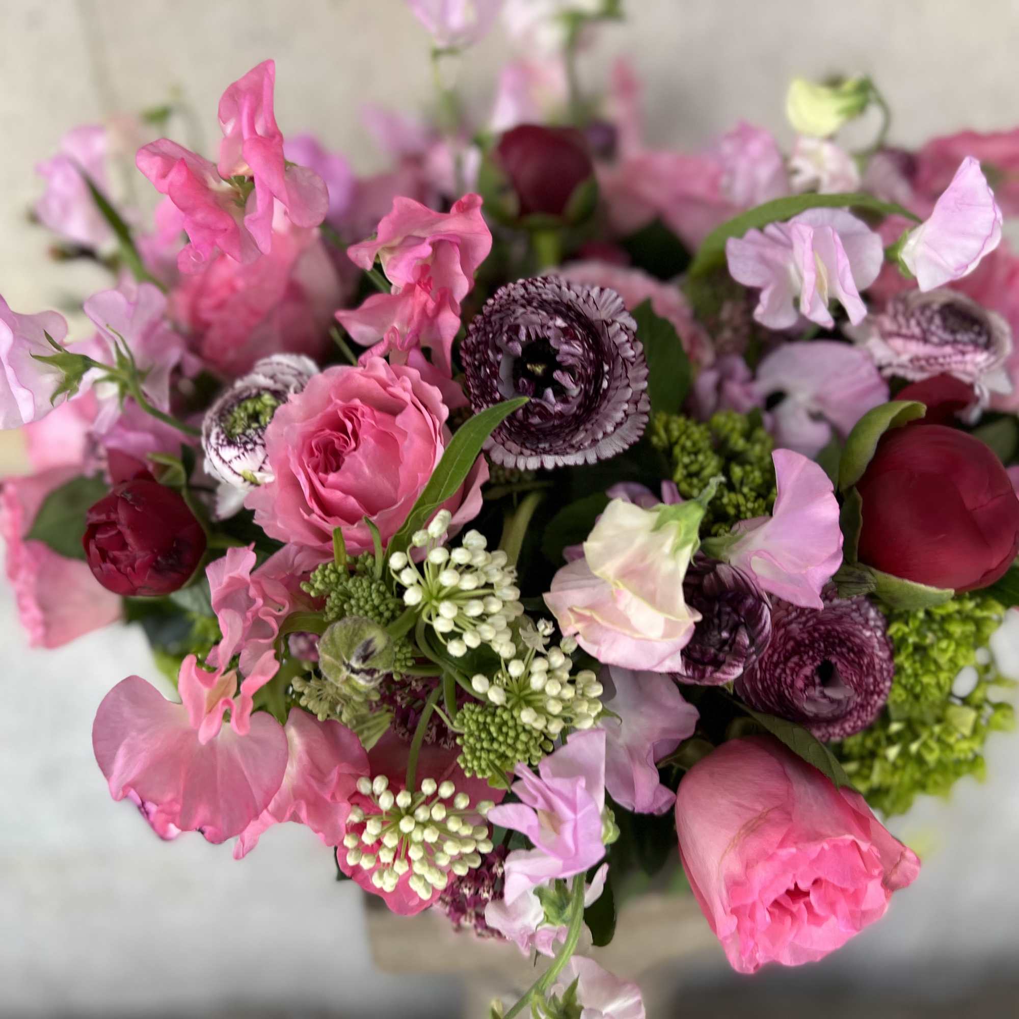 Pink and burgundy mixed bouquet with sweet peas and ranunculus