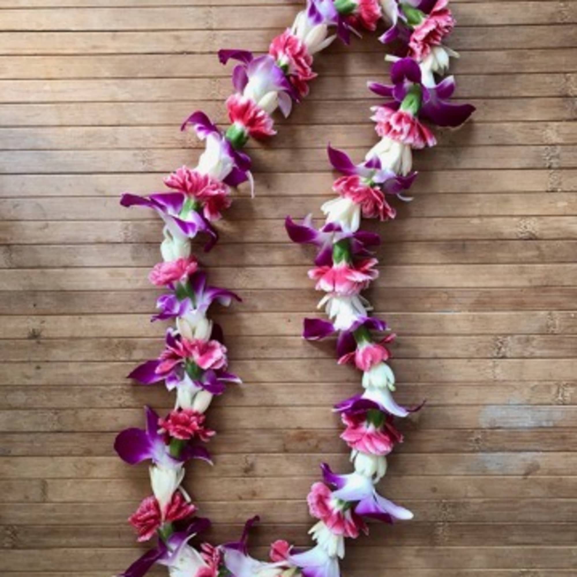 Mini carnations, orchids, and tuberose lei is a beautiful, lightweight fragrant lei.