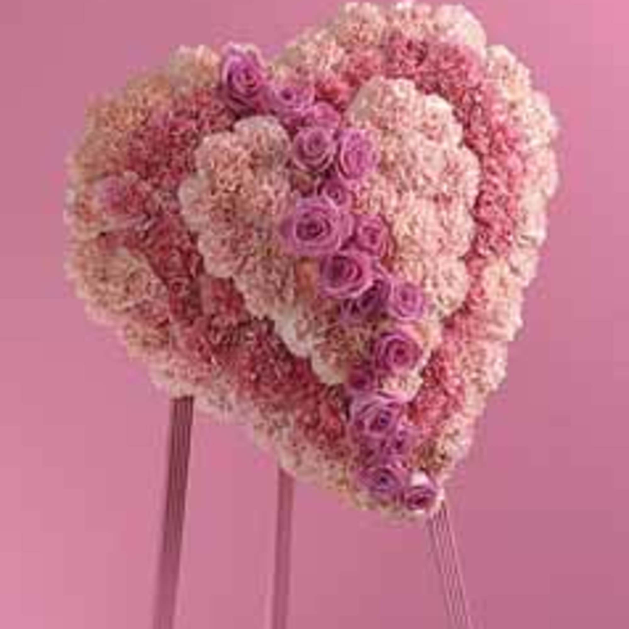 Heart-shaped pink floral arrangement on a stand