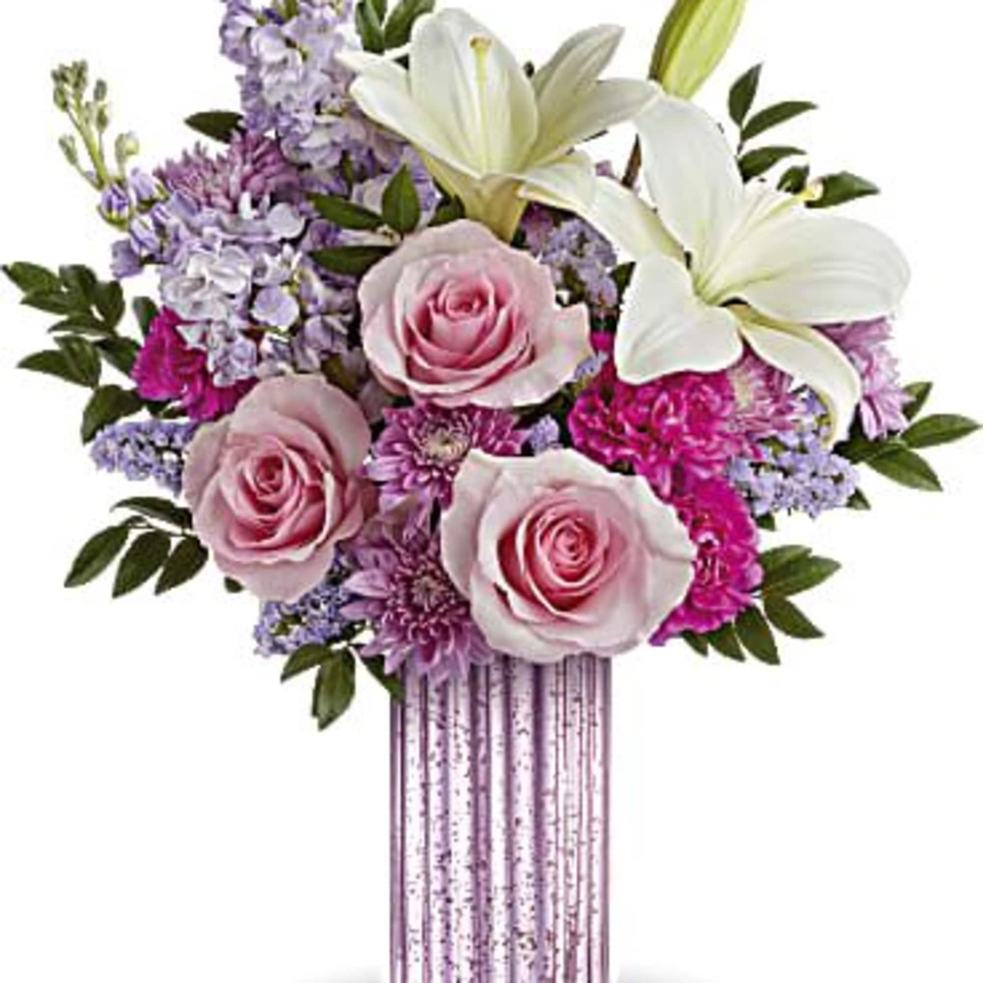 Tall pink ribbed vase with white lilies, pink roses, and lavender mixed flowers