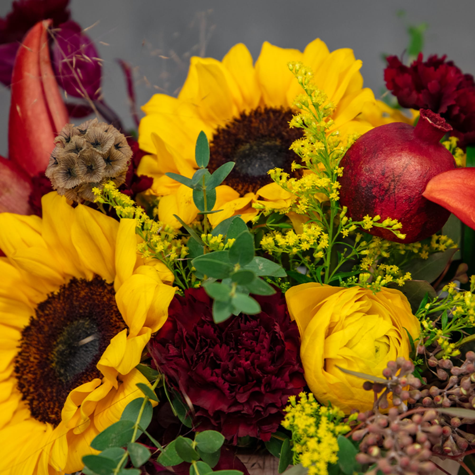 Bouquet with yellow sunflowers, burgundy blooms, and red calla lilies