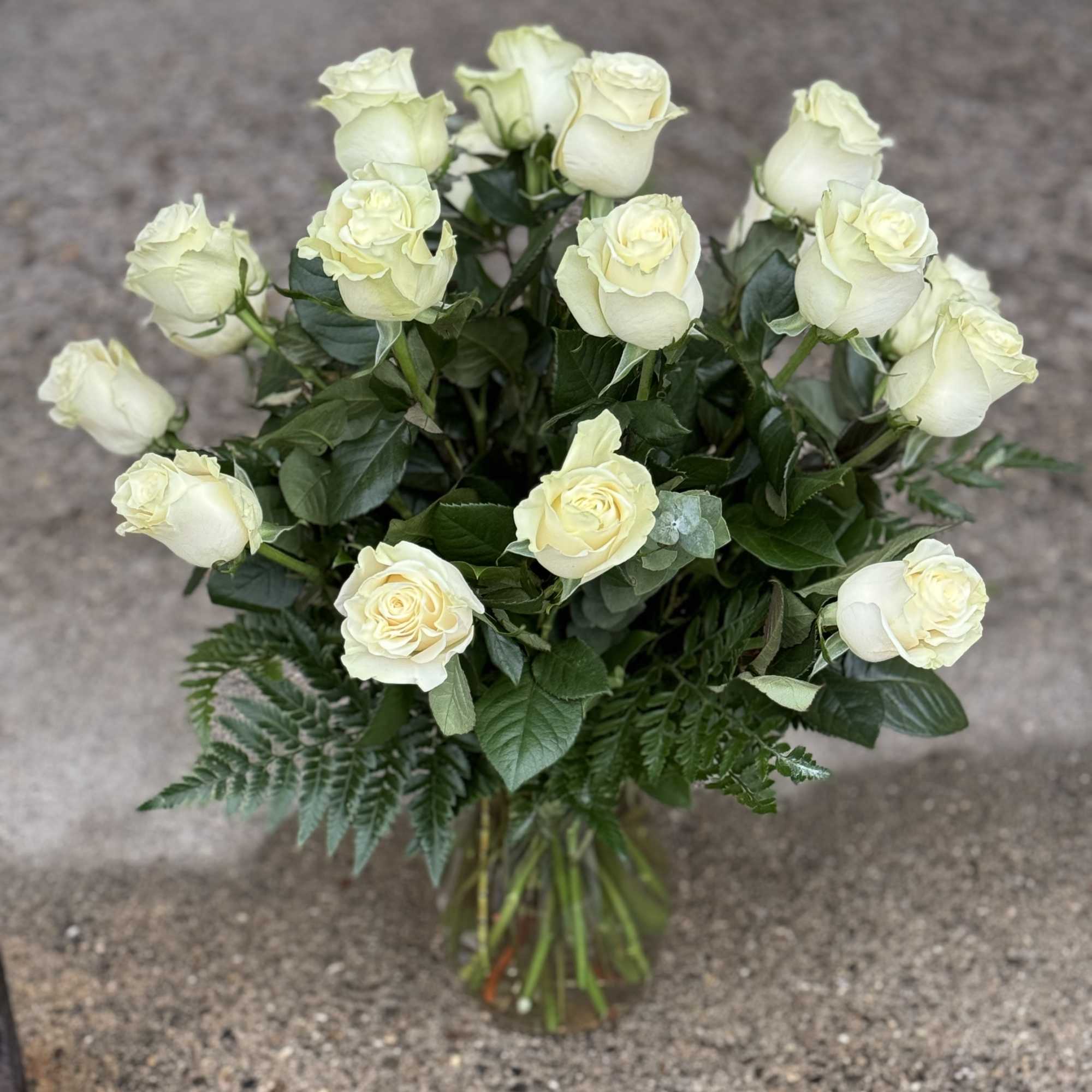 Bouquet of cream white roses in a clear glass vase