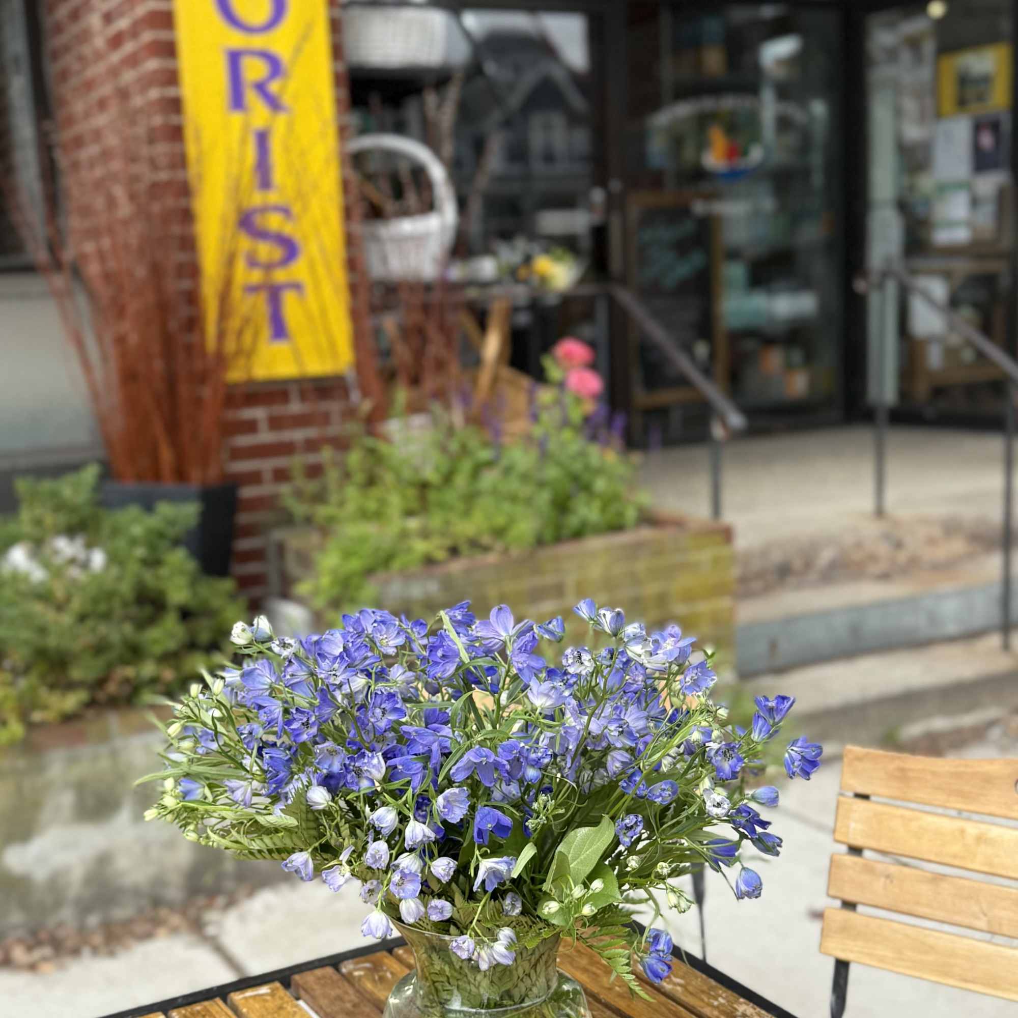 Blue flowers arranged in a clear glass vase on a wooden table