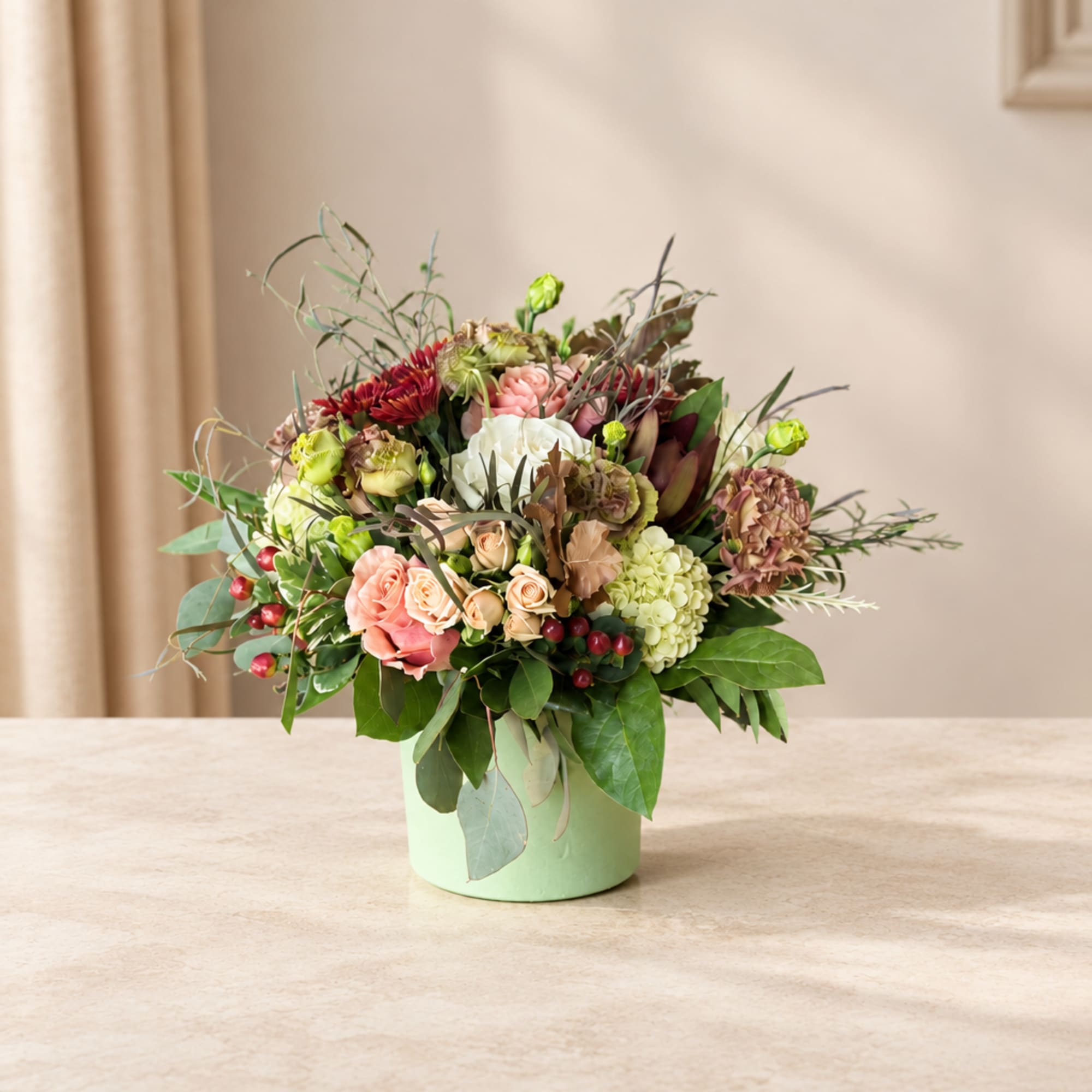Mixed bouquet in a pale green vase with pink, white, and burgundy blooms