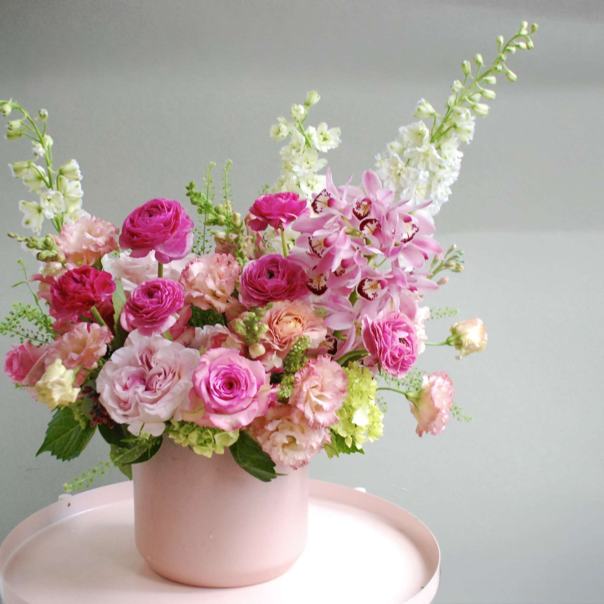 Pink and white floral arrangement in a blush vase