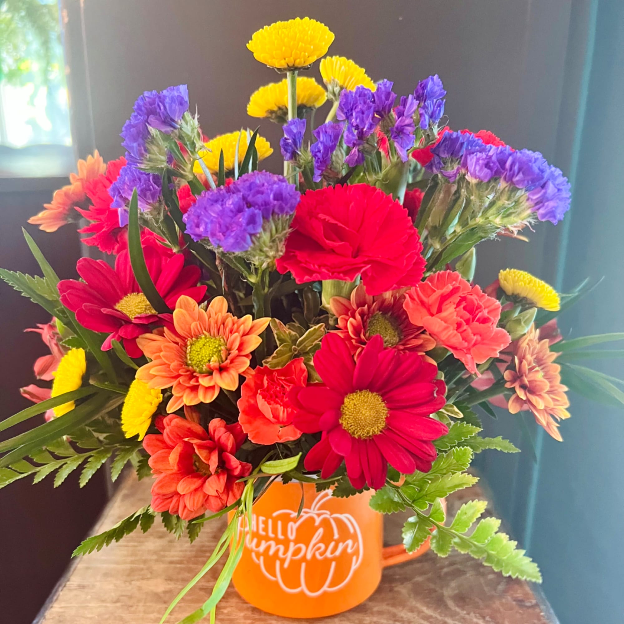 Colorful mixed bouquet in an orange mug with a pumpkin design