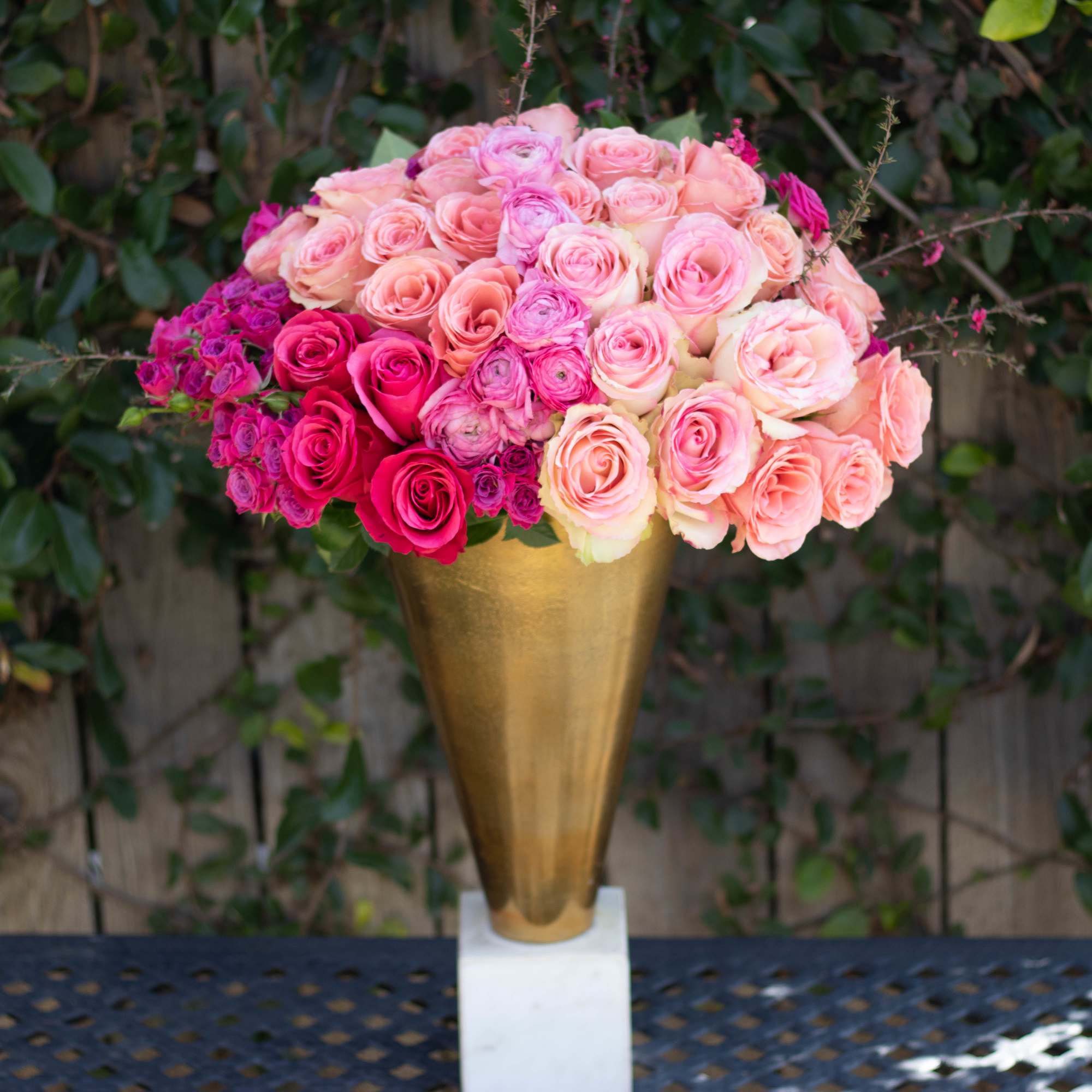 Pink and peach roses arranged in a gold vase