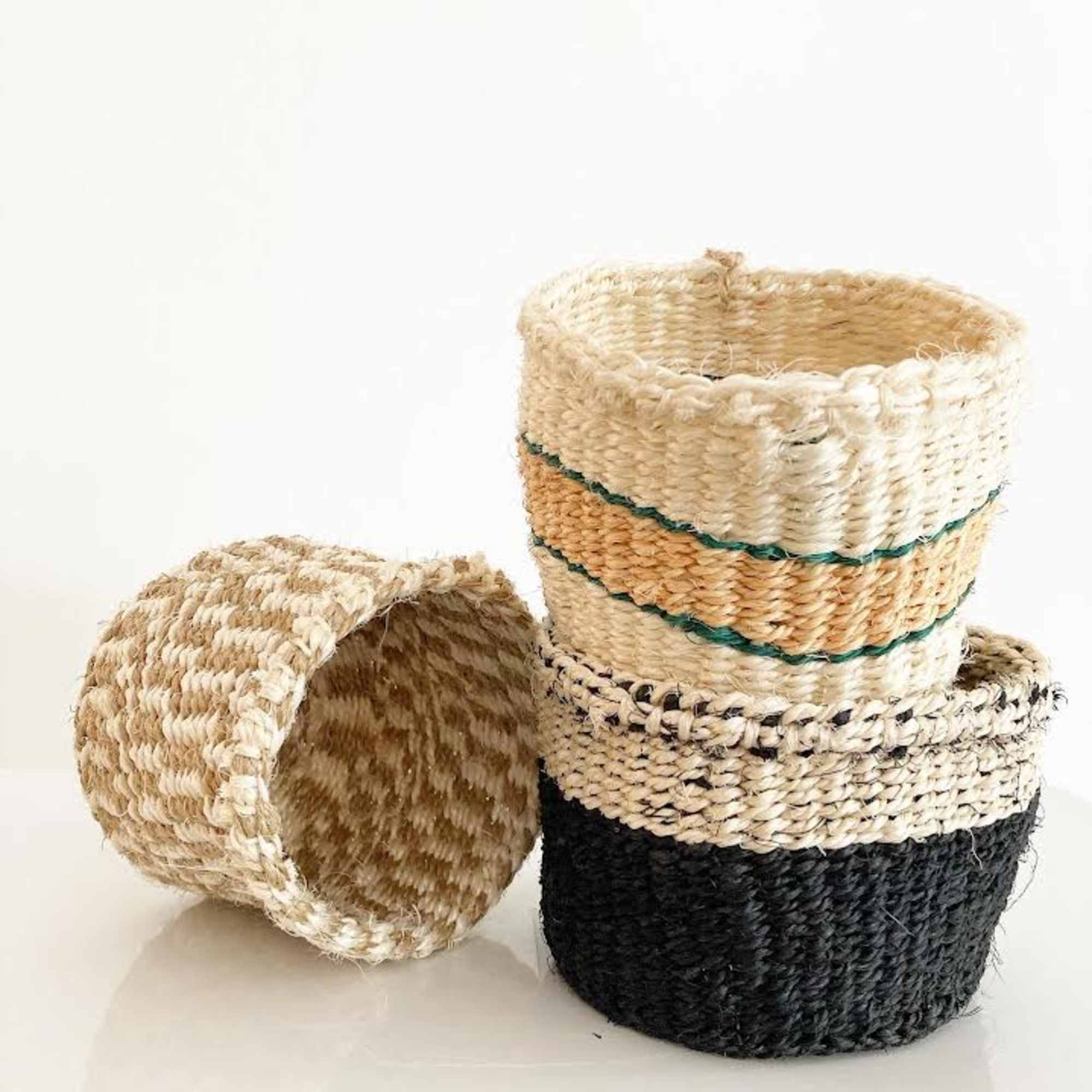 Stack of woven plant baskets in natural and black tones