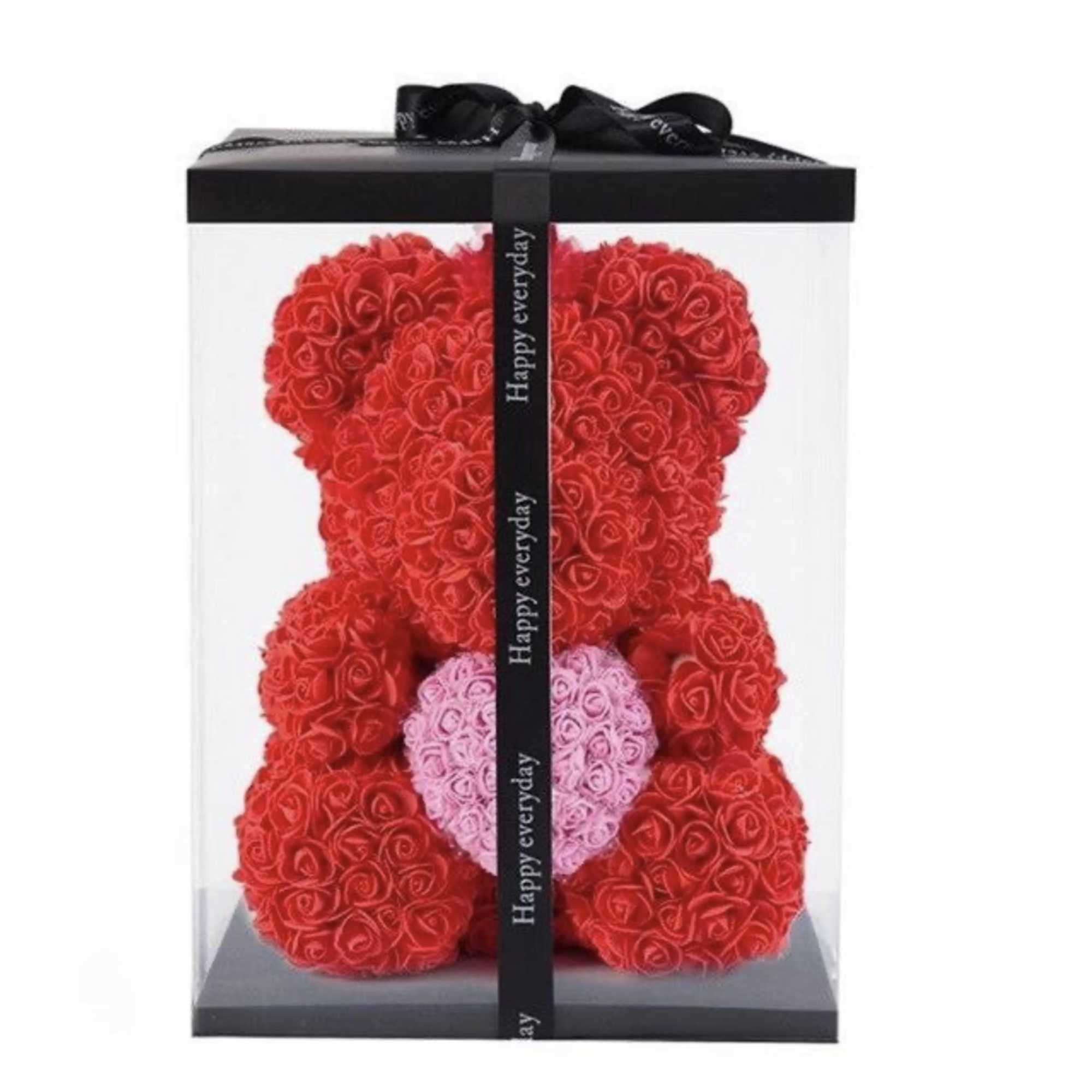 Red rose teddy bear holding a pink heart, displayed in a clear box with black ribbon