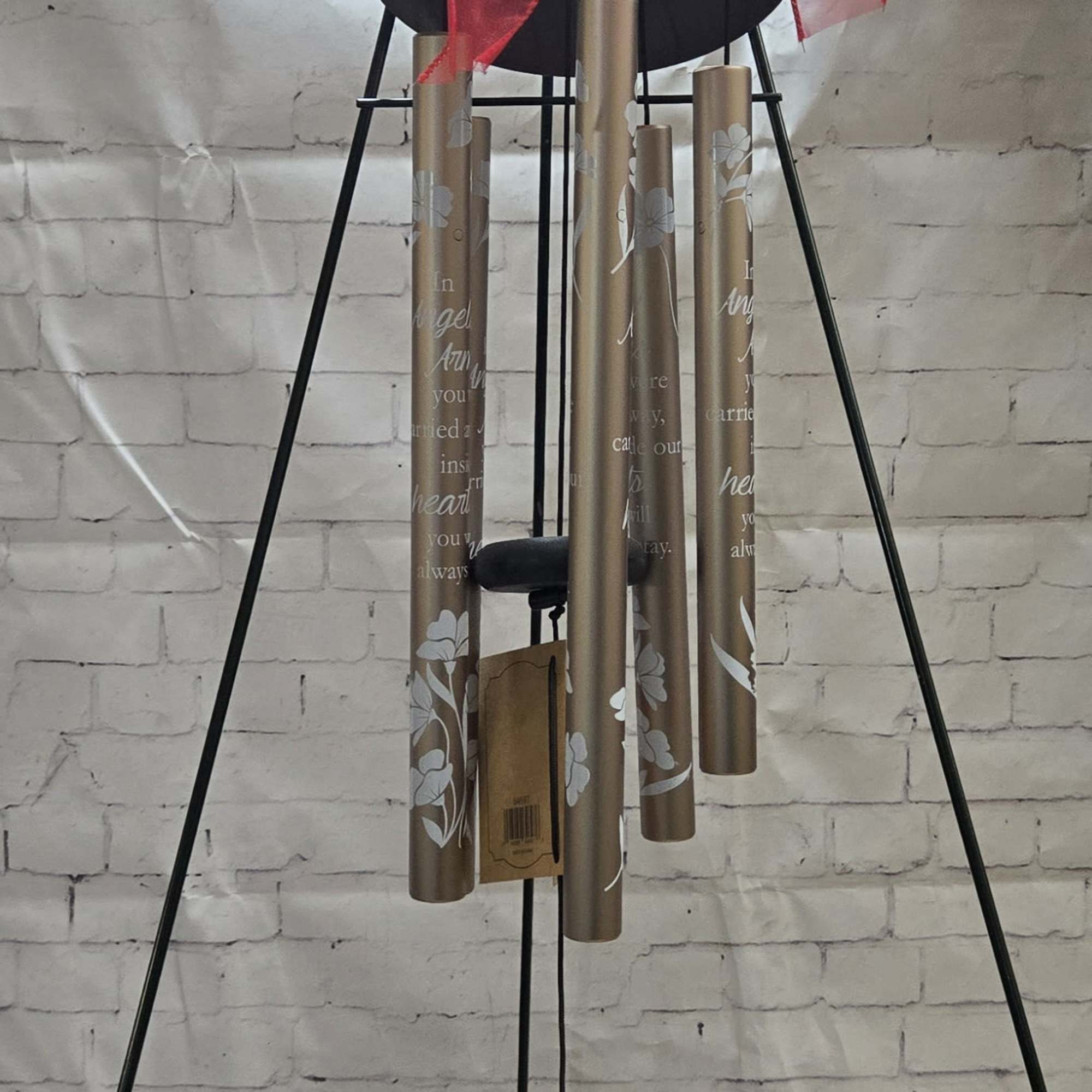 Wind chime with a red ribbon bow and hanging bronze tubes