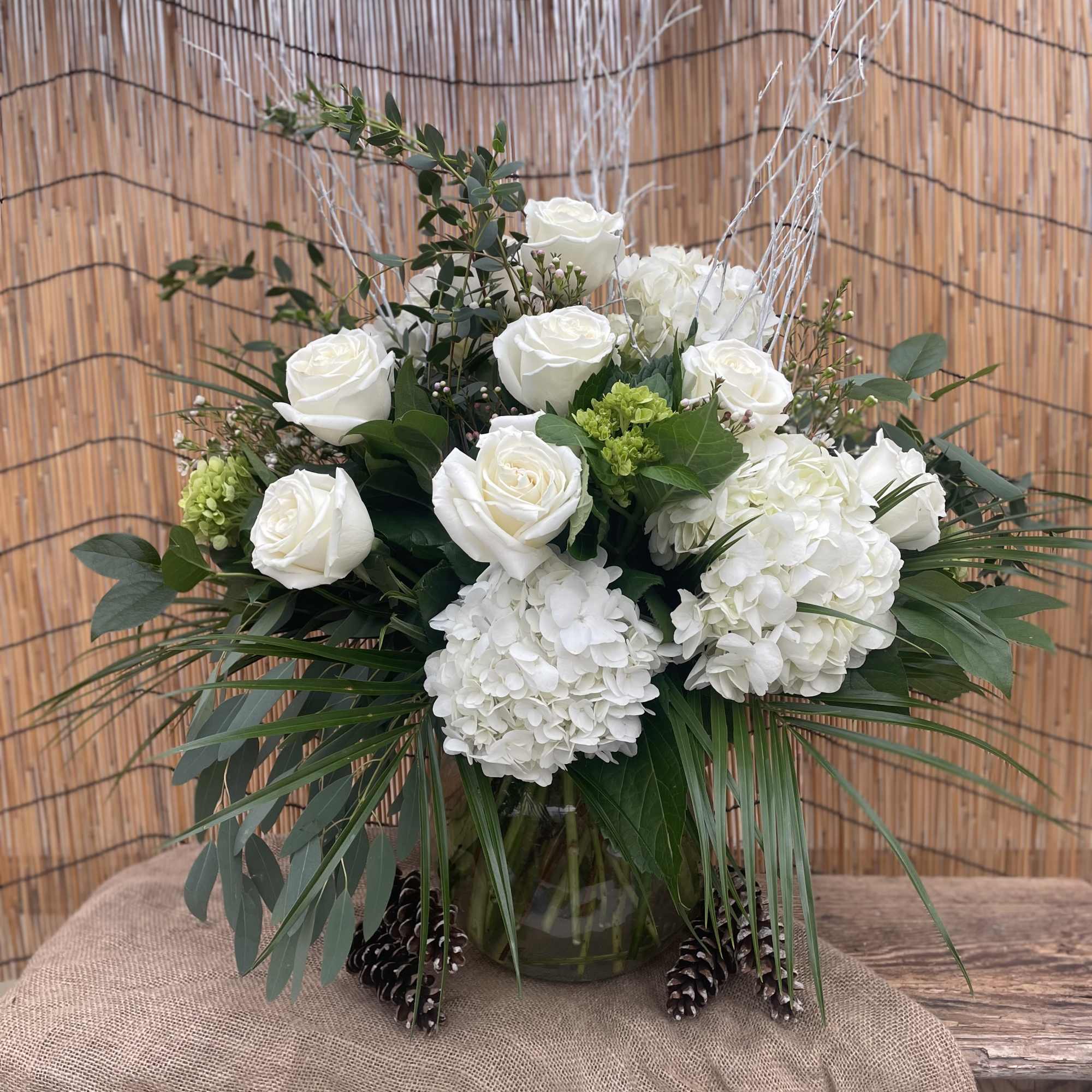 White roses and hydrangeas arranged in a glass vase